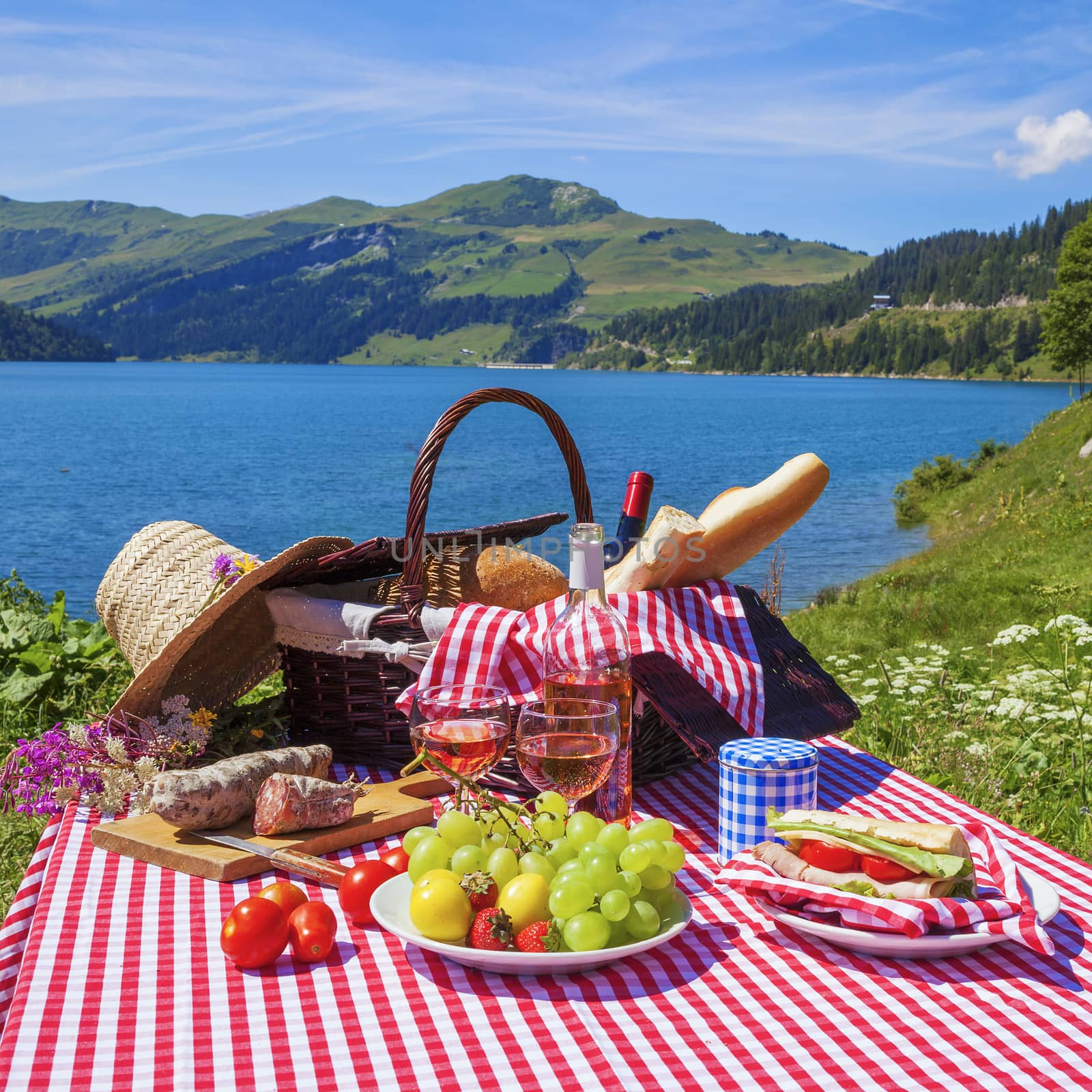 Picnic in alpine mountains with lake on background, panoramic view