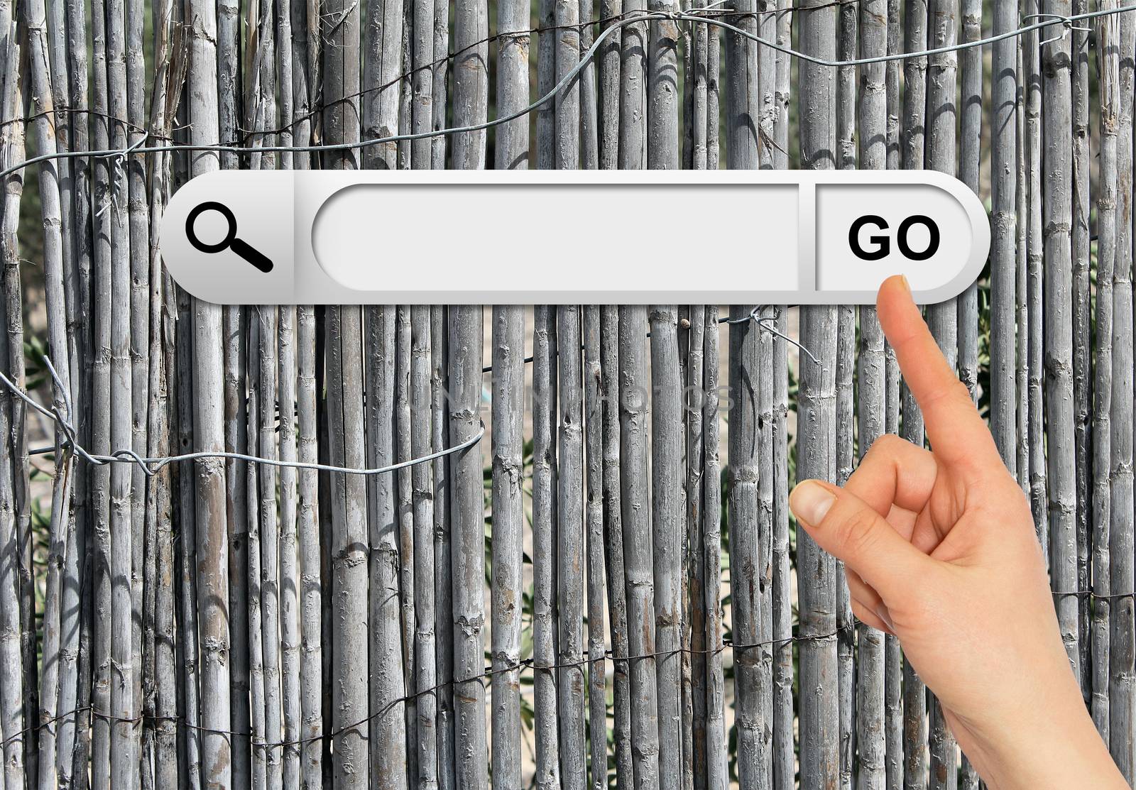 Human hand indicates the search bar in browser. Old gray wooden fence on background