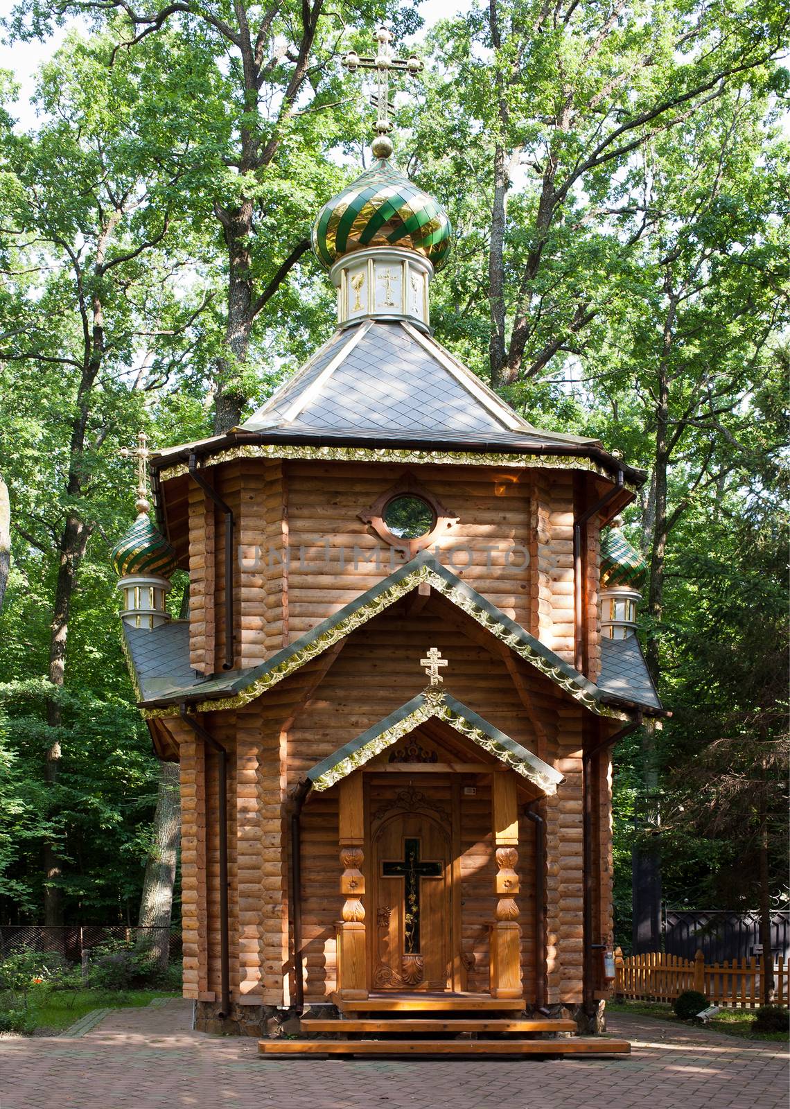 General view of a two-story log house of prayer in the woods