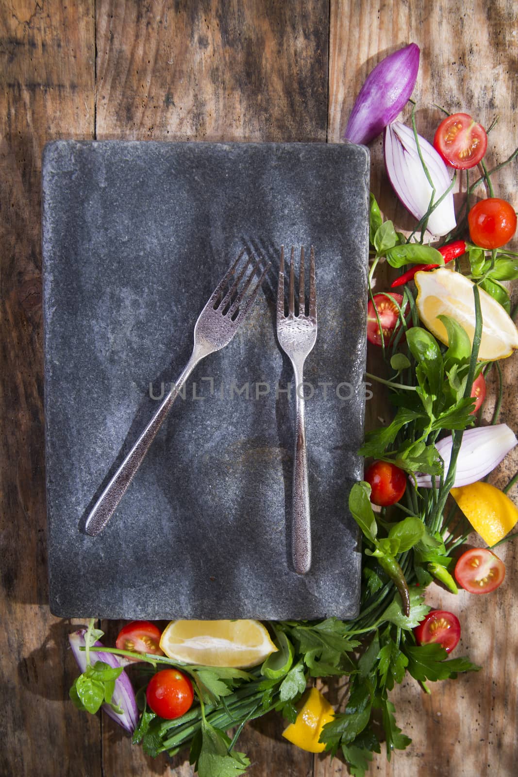 Presentation of a flat stone with vegetables