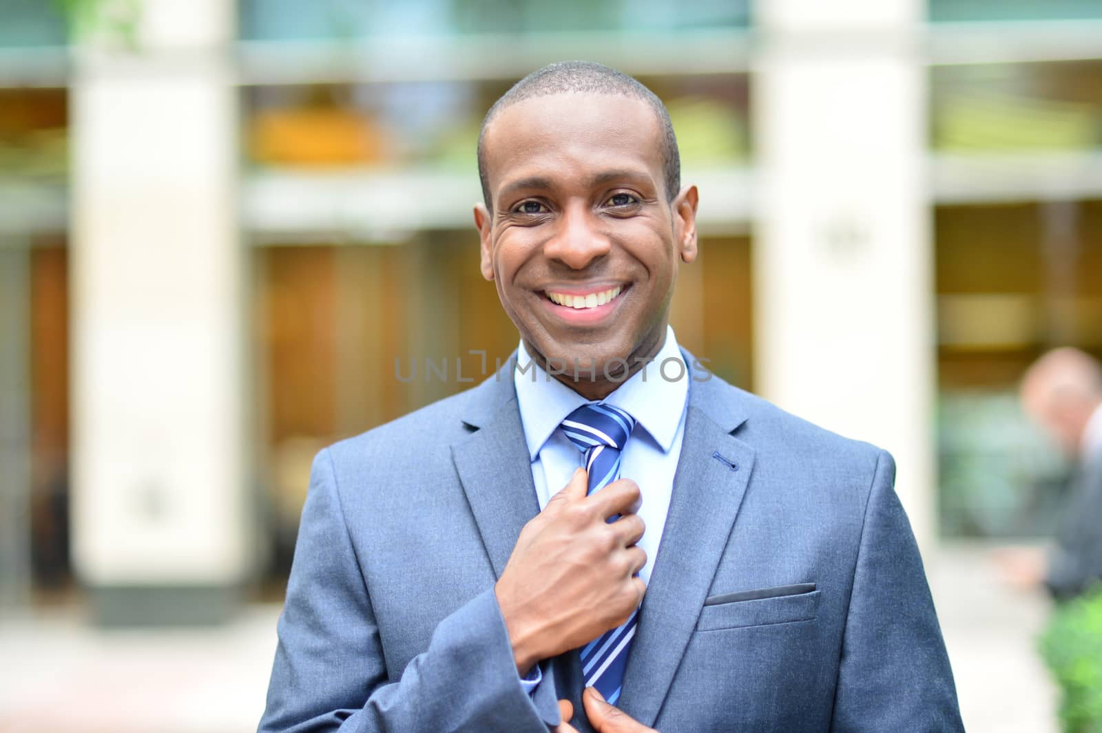 Handsome businessman fixing his tie outdoors