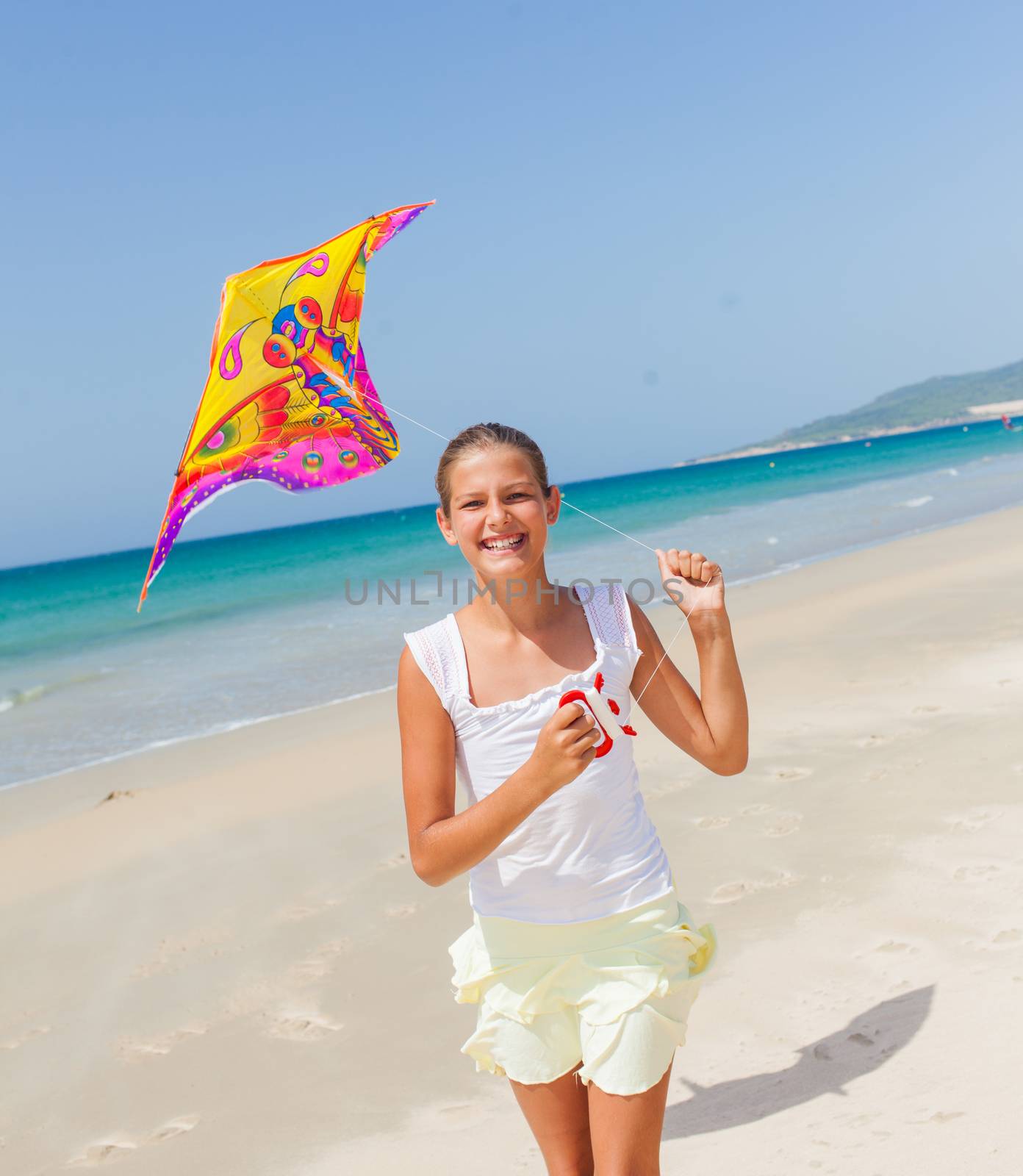 Summer vacation - Cute girl flying kite beach outdoor.