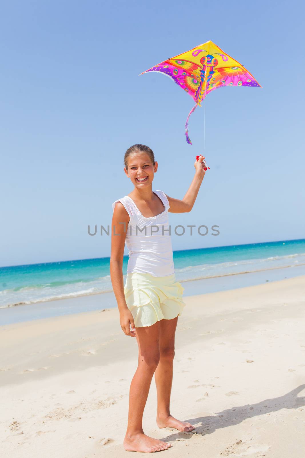 Summer vacation - Cute girl flying kite beach outdoor.