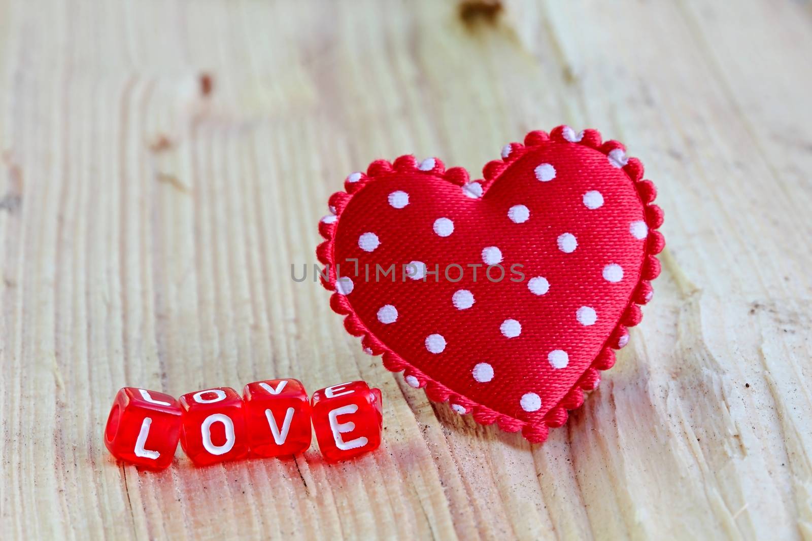 Photo shows details of love sign with heart on the wooden background.