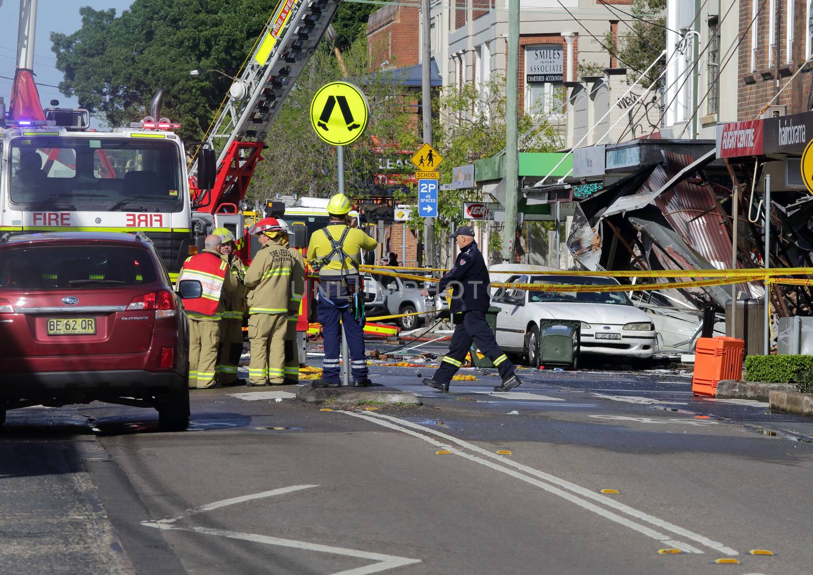 ROZELLE, AUSTRALIA - SEPTEMBER 4, 2014;   Firefighters and rescue crew discuss an action plan for a search and resue mission after an explosion at a convenience store.   Grave fears are held for three missing people who resided in the building upstairs.  Darling Street, Rozelle, Sydney, Australia.  Police are treating the explosion as suspicious