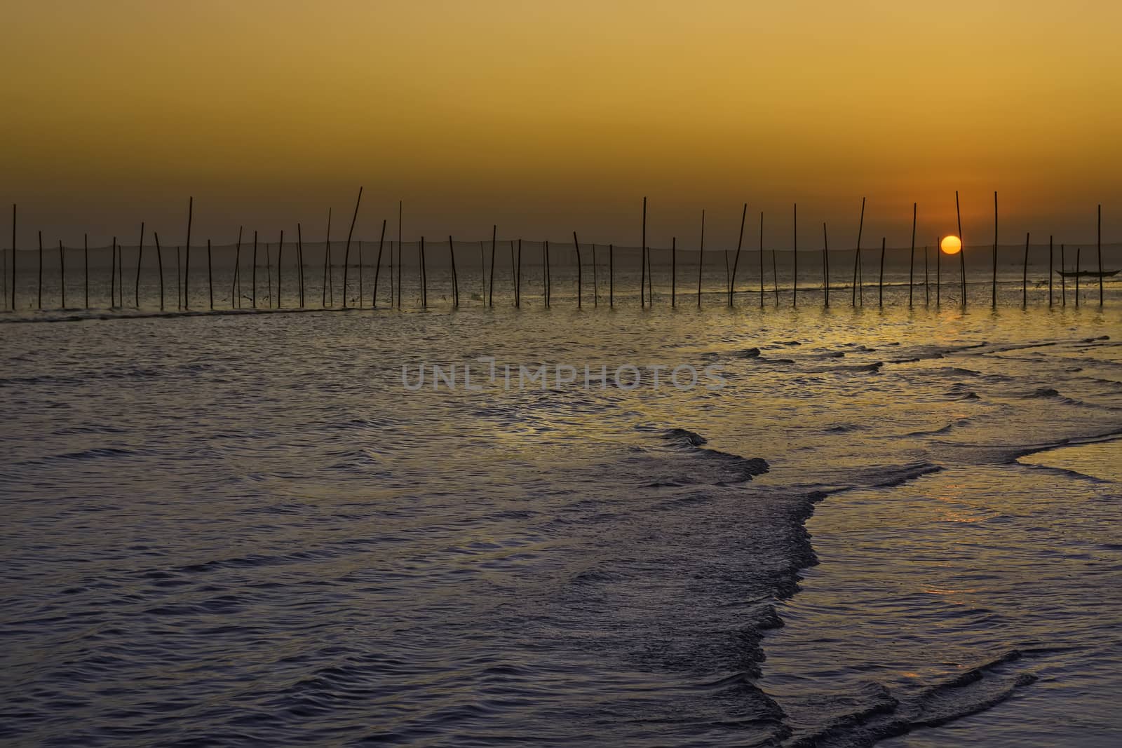 Fiery beach sunset over a fishing village in the Philippines.