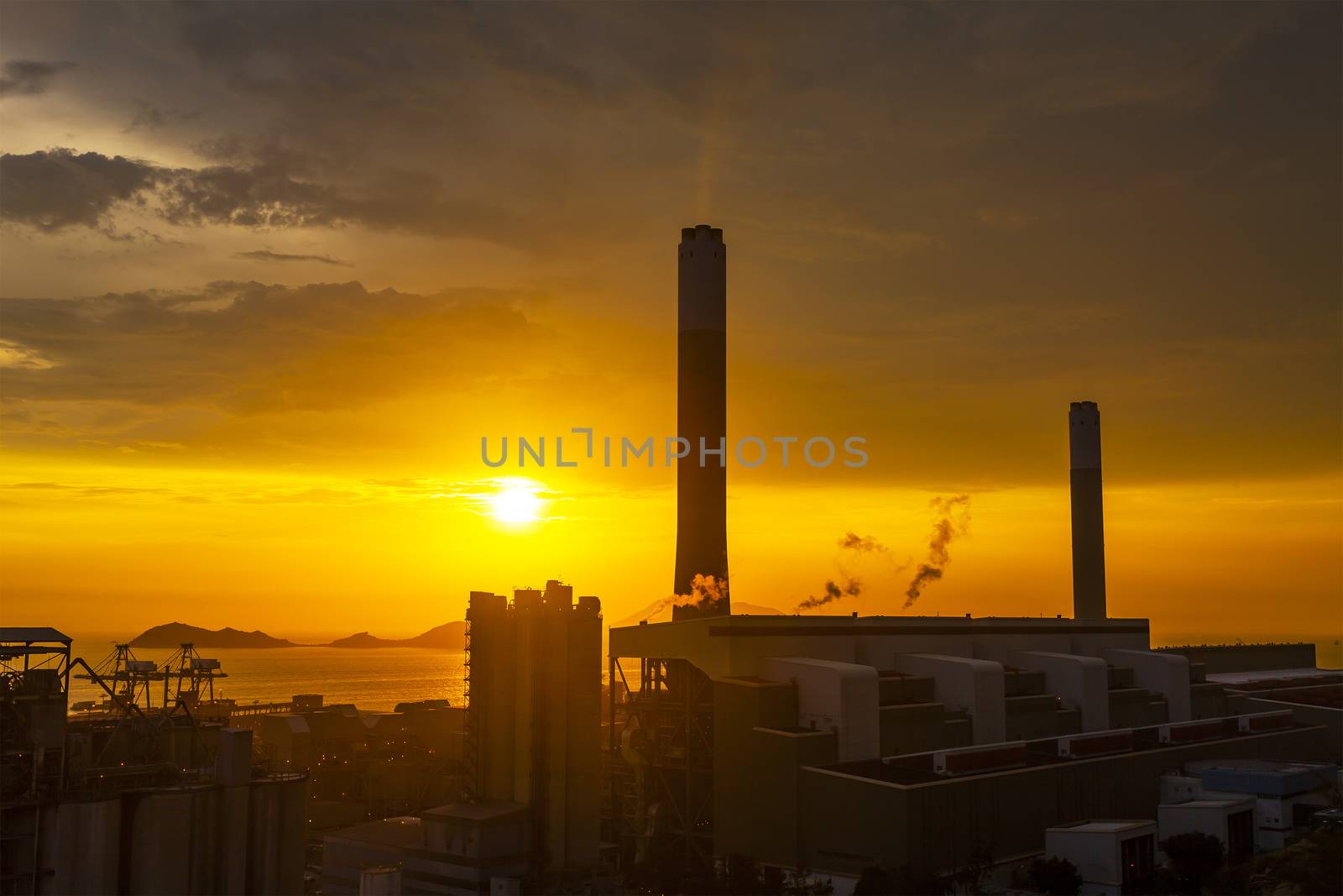Silhouette of gas turbine electrical power plant against sunset

