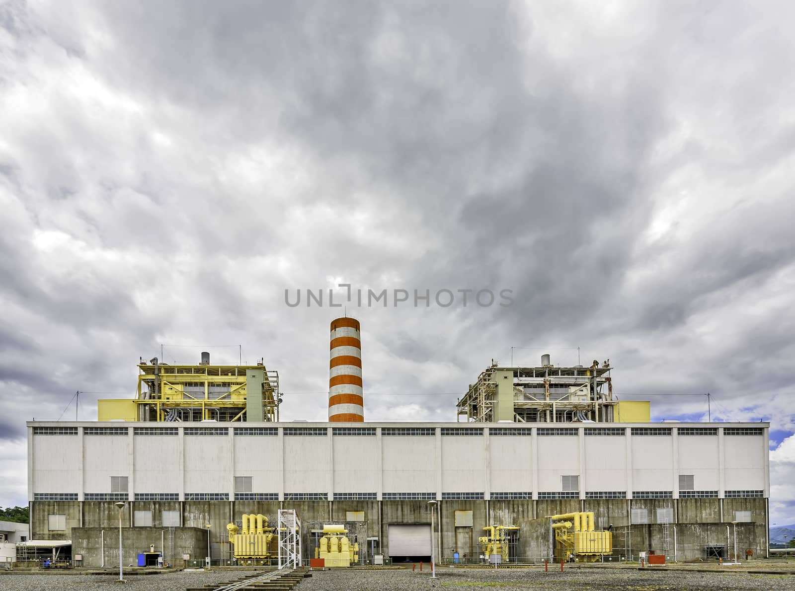 Old coal power plant in Asia shot against ominous dark clouds