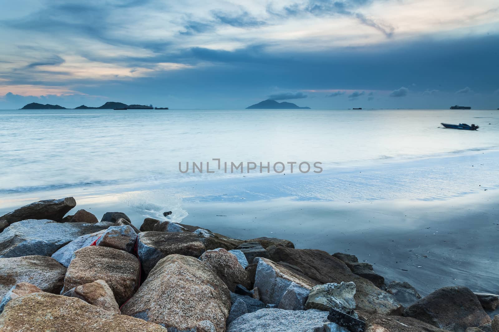 Sunset at coast with sea stones background