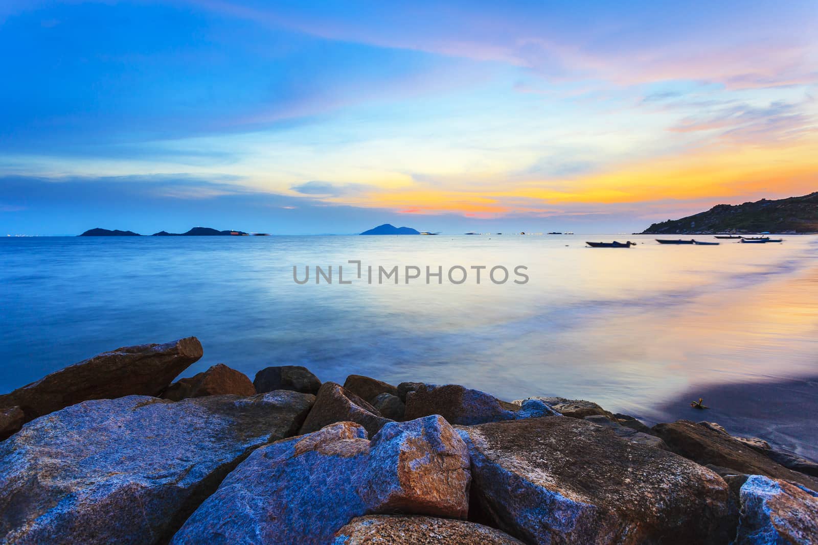 Sunset along the coast with sea stones background