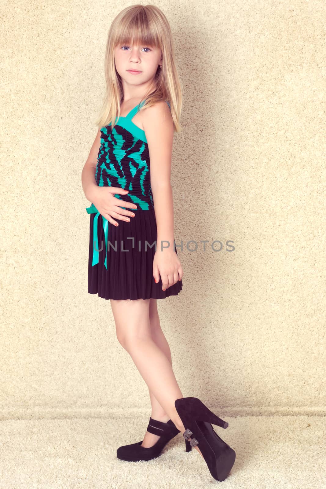 5 years old girl in big shoes with heels studio shot
