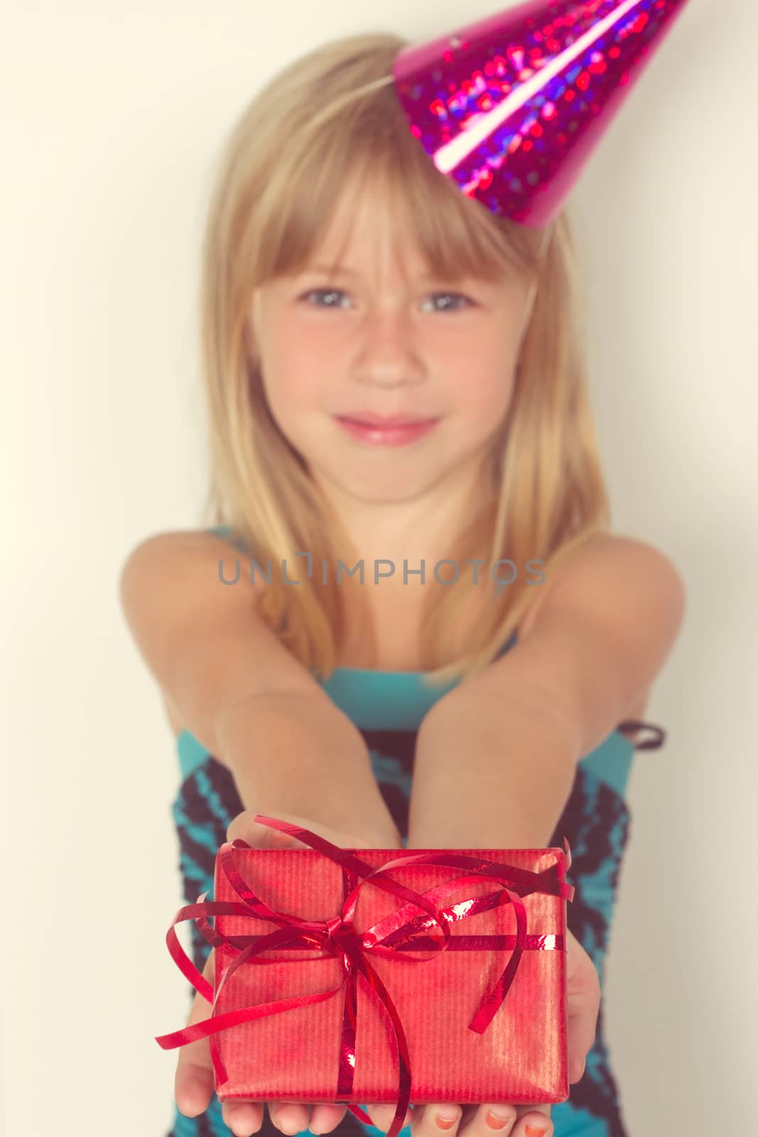 Girl 5 years with a birthday gift and cap