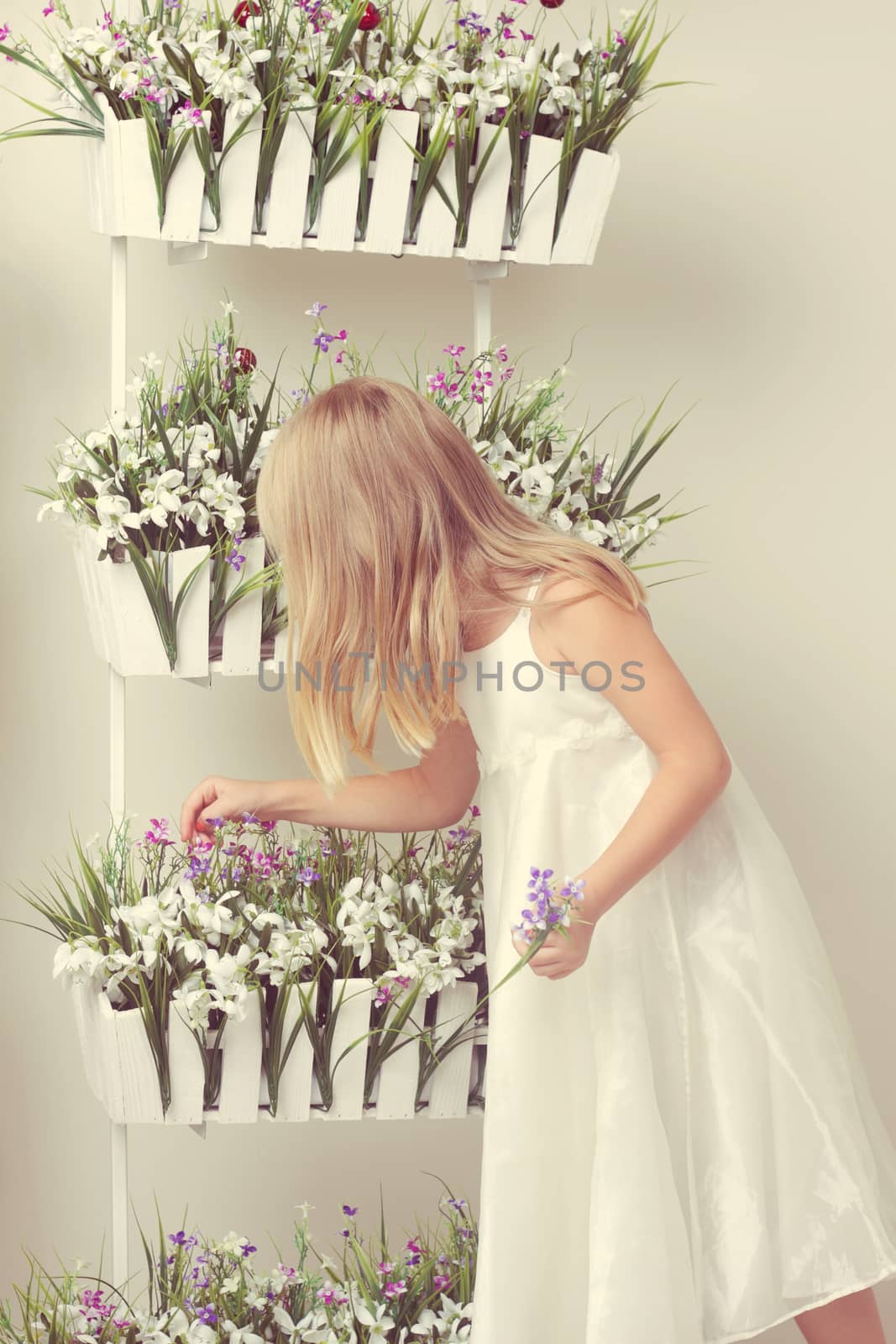 beautiful girl with summer flowers in the garden center