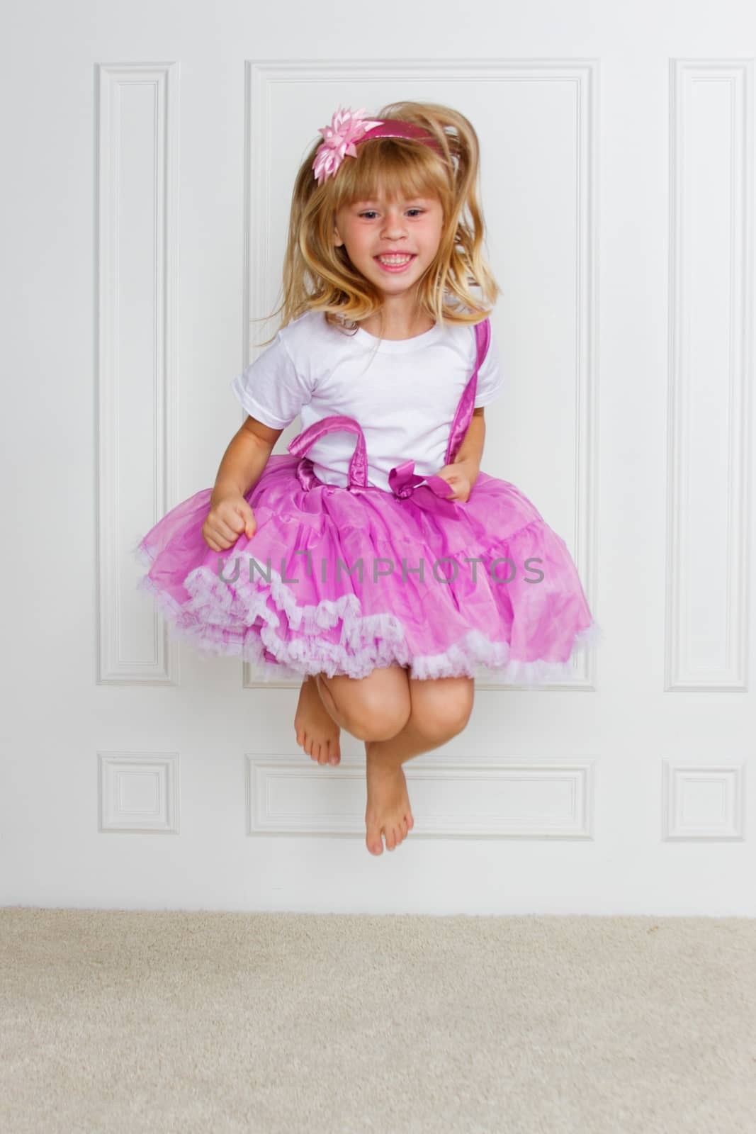 Jumping Excited Girl wearing beautiful dress on white