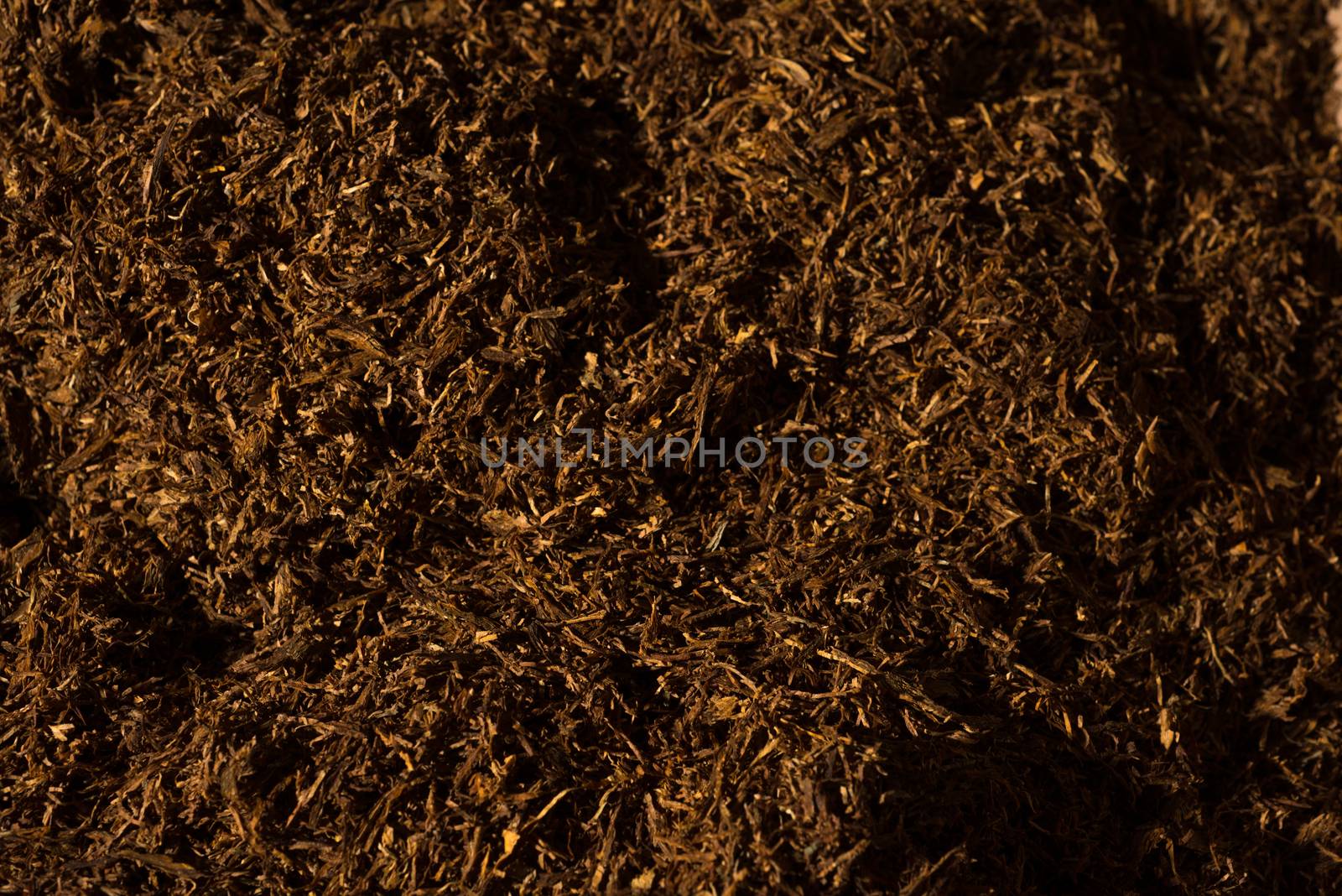 Fine cut tobacco background detail inside a cigarette production machine