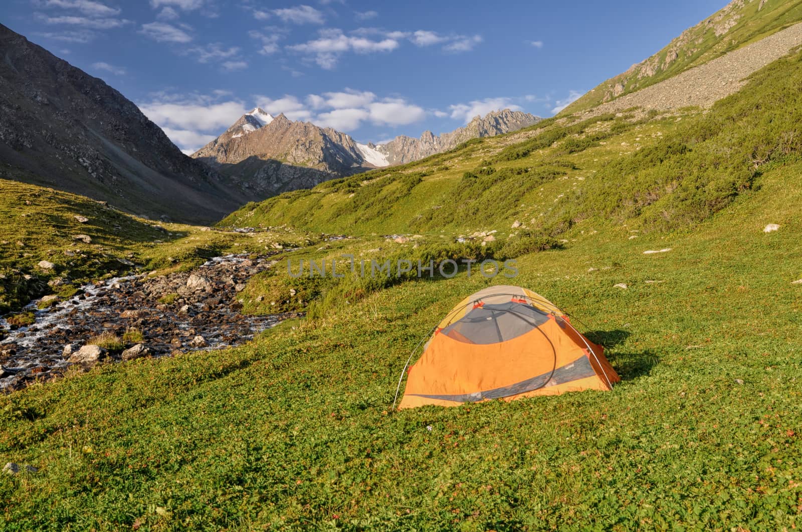 Hiker's tent on a slope in Tian-Shan Mountains, Kyrgyzstan 