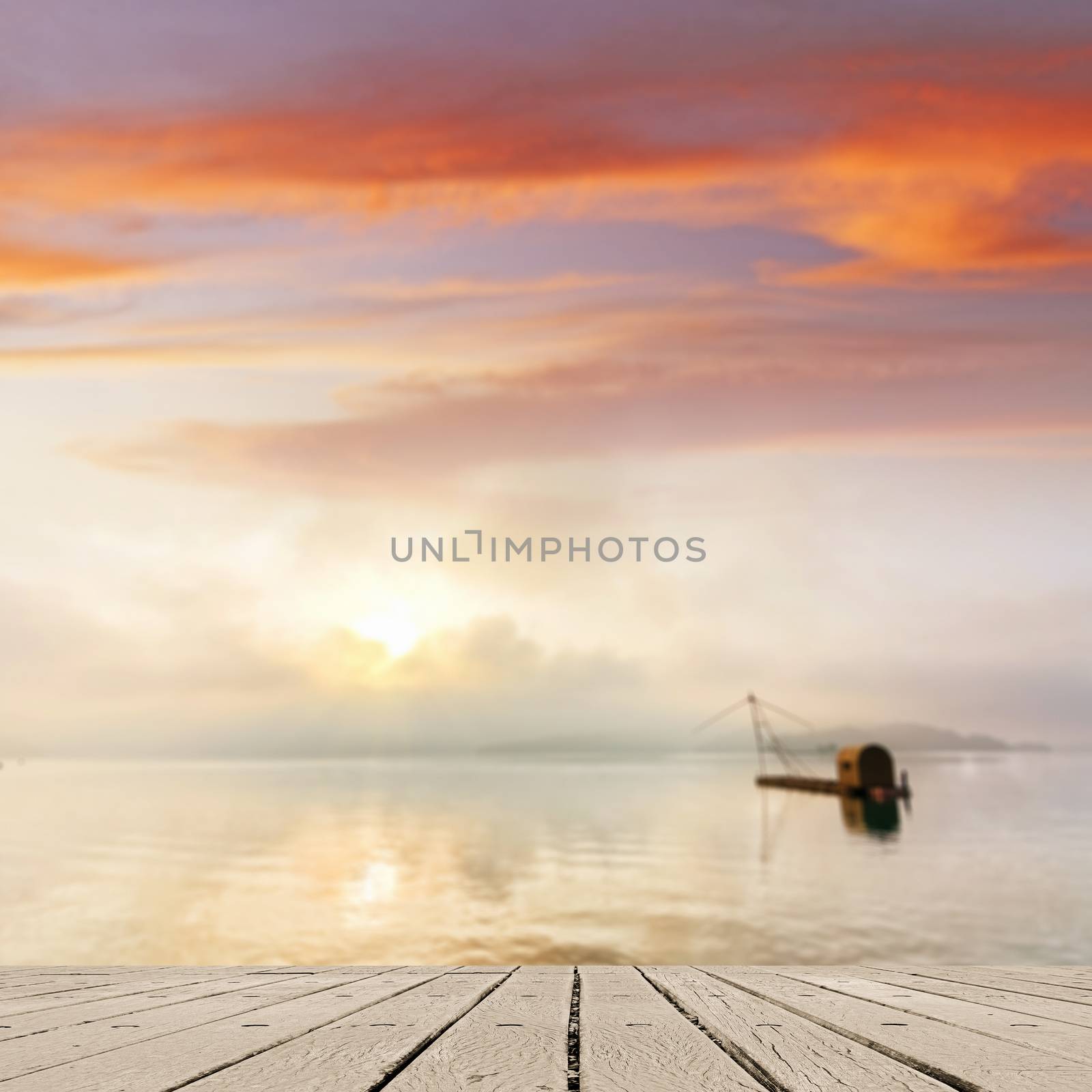 Morning concept with boat on lake with sunlight and dramatic sky, focus on wooden desk.