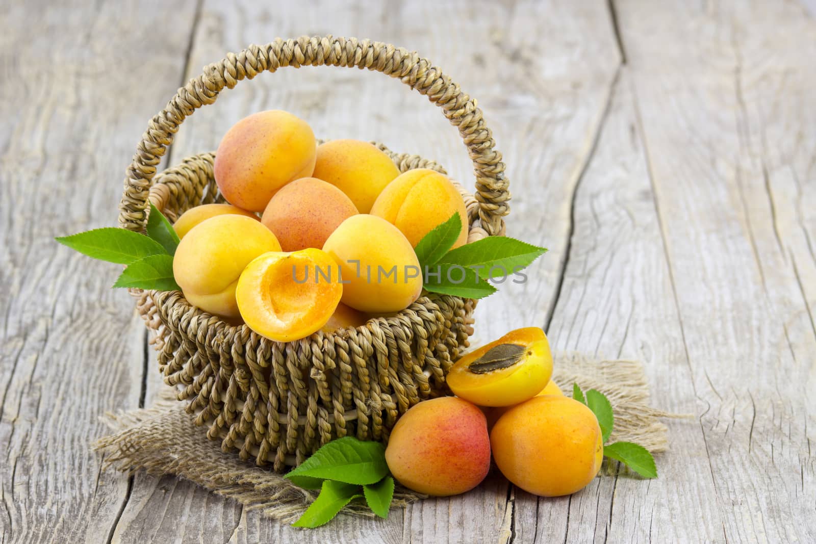 fresh apricots in a basket on wooden background