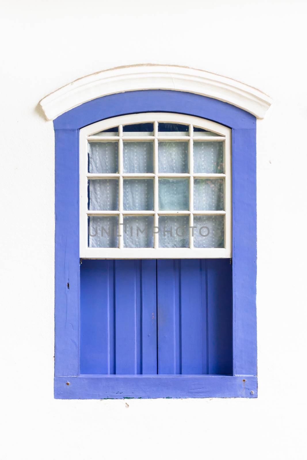 Decorative, colonial, blue, vintage, window on a white wall in Paraty (or Parati), Brazil.