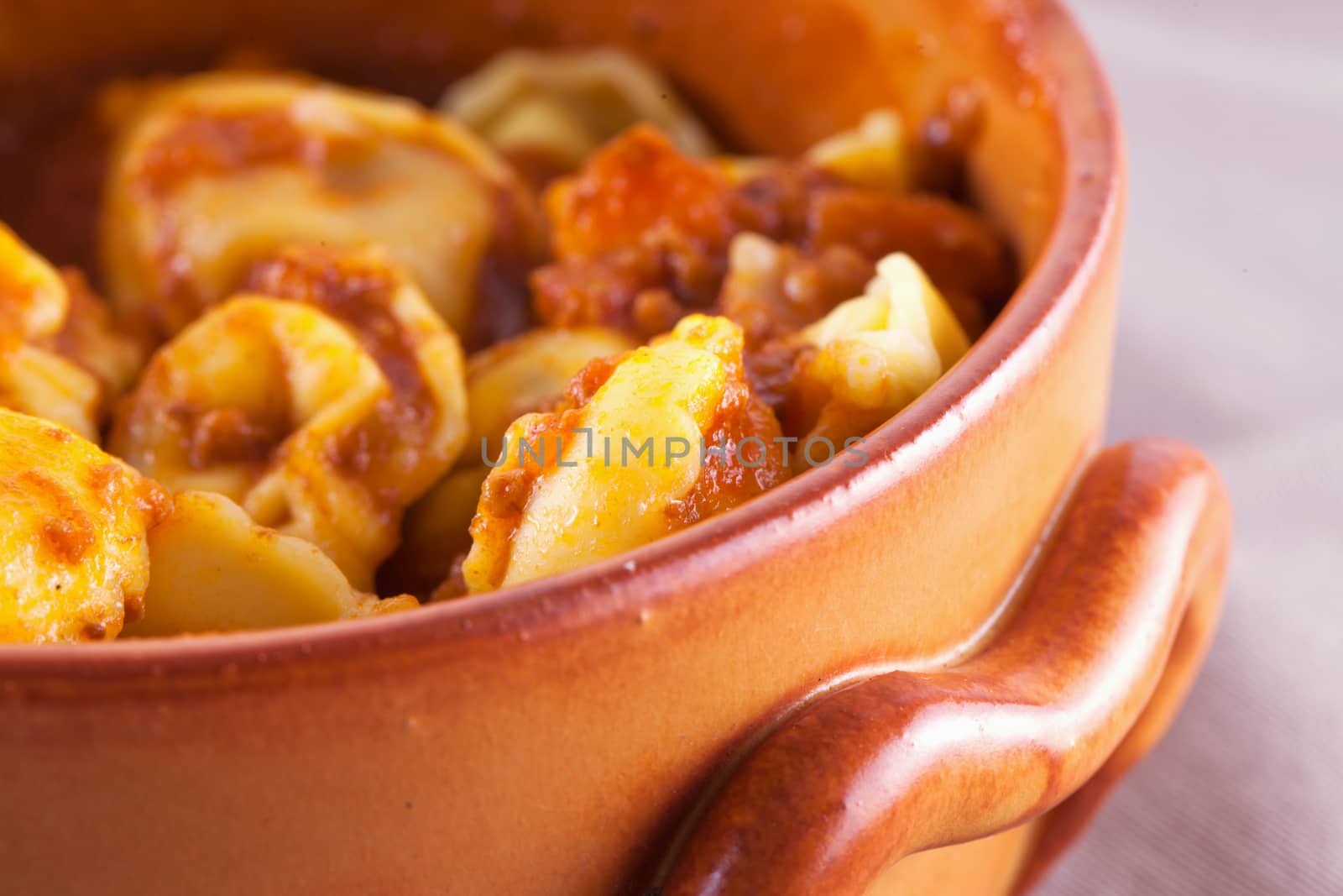 Agnolotti with tomato sauce in crock pot, close up