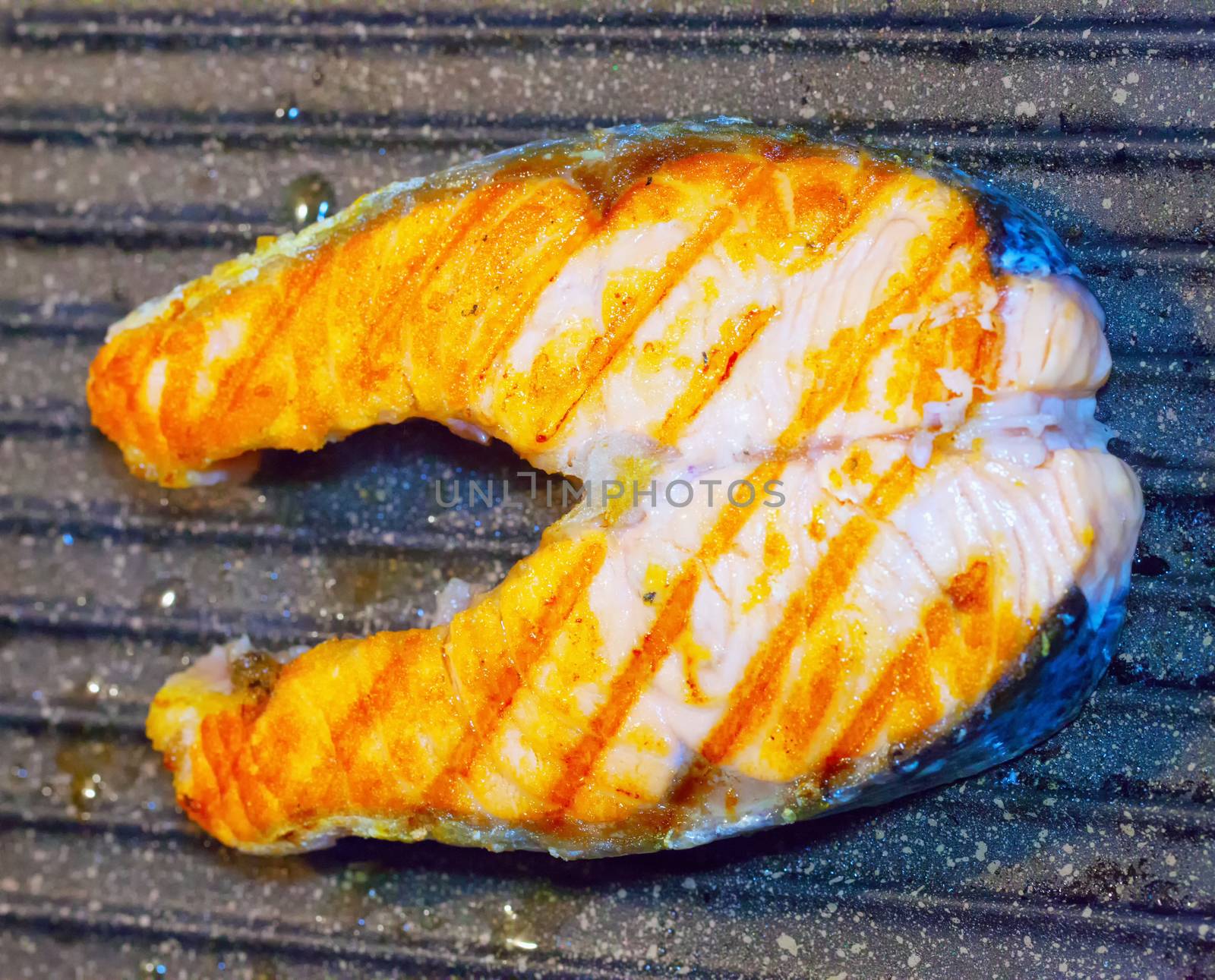 Slice of salmon grilled over stone pan