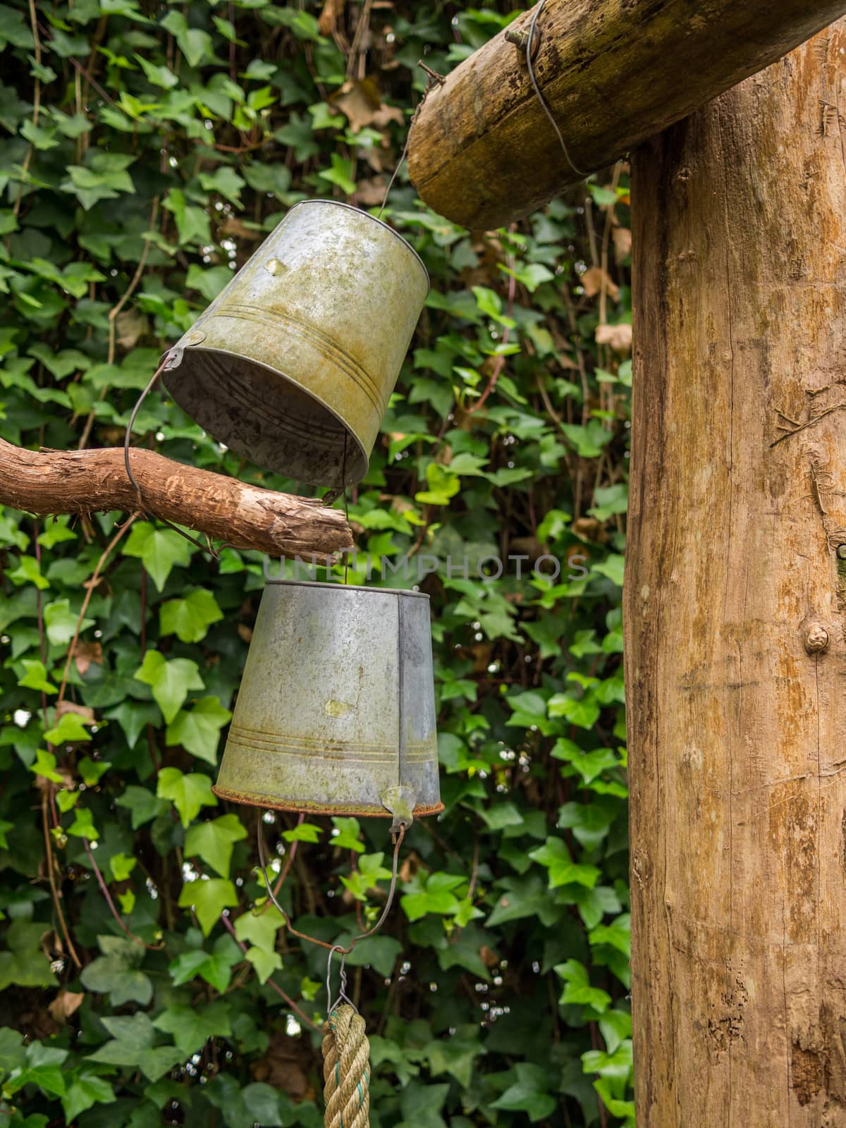 Old rusty buckets hanging from pole by frankhoekzema