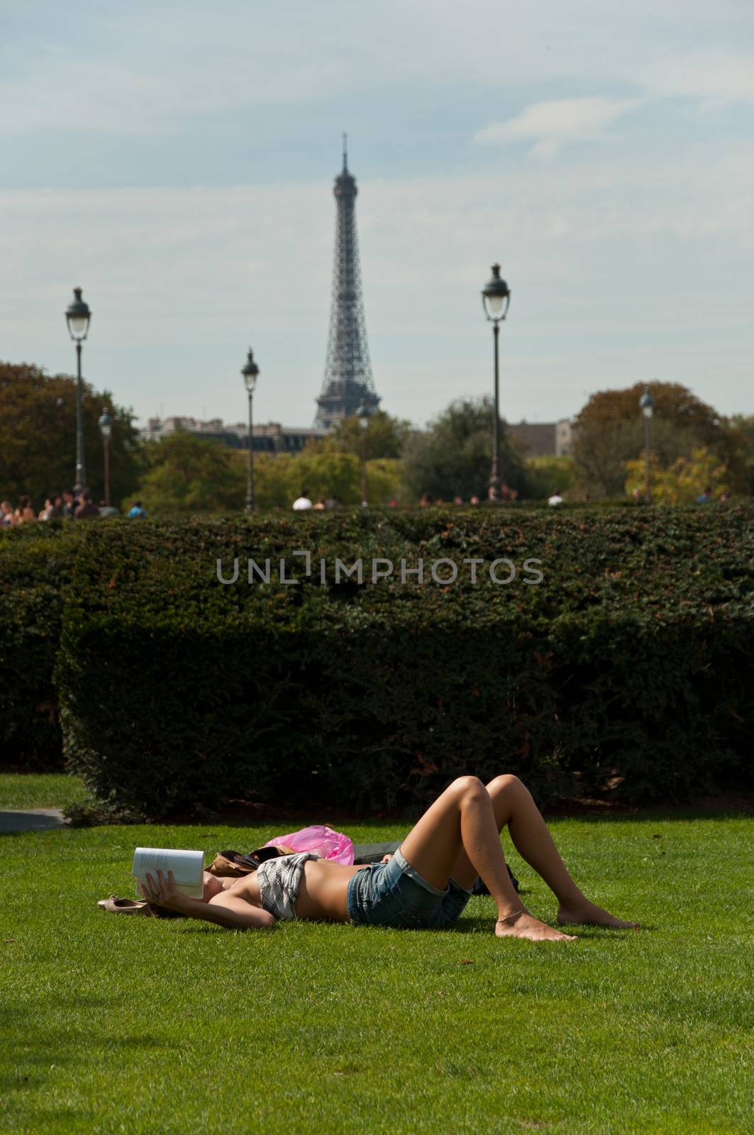 sexy girl on grass on Tuileries garden in Paris by NeydtStock