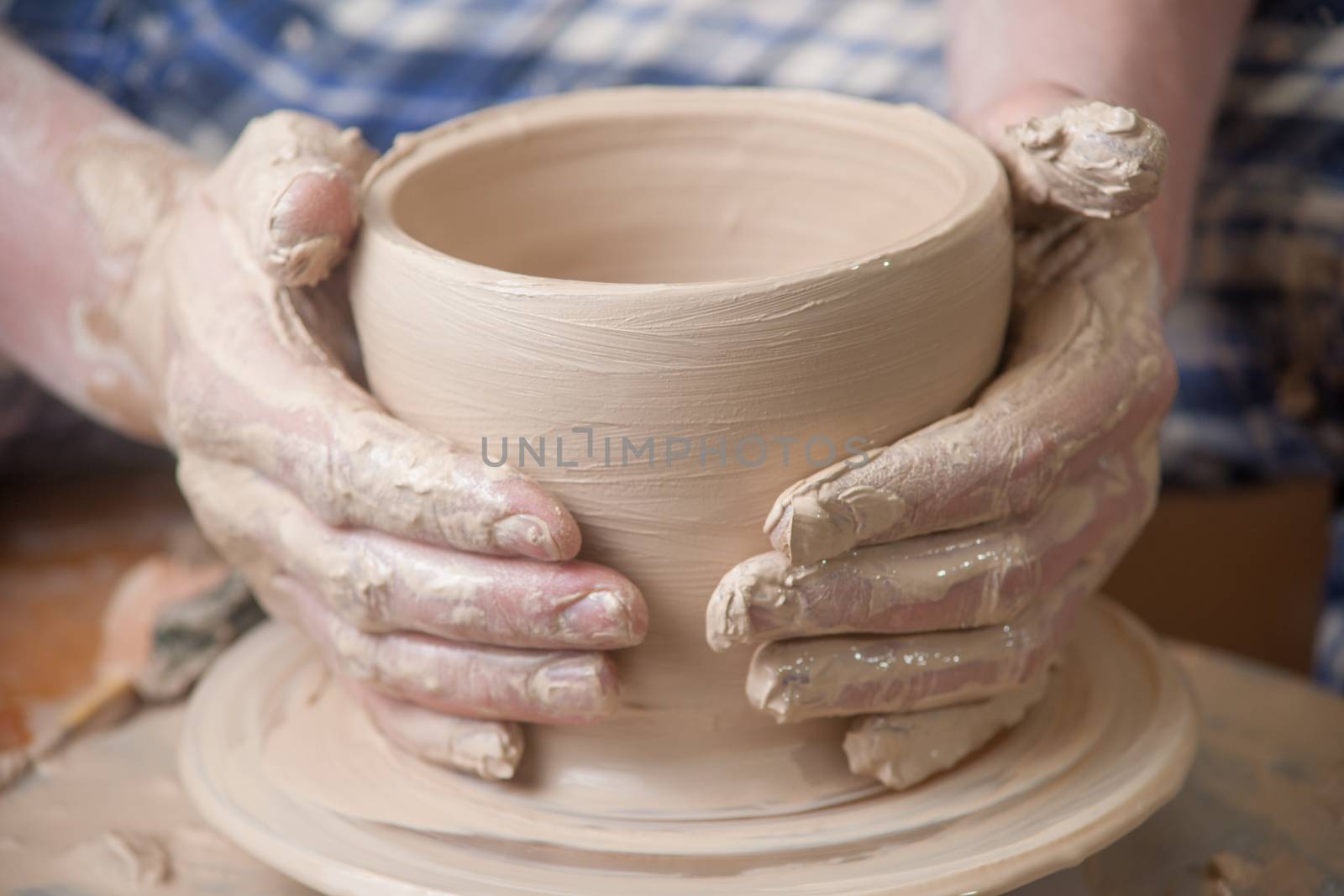 Hands of a potter, creating an earthen jar on the circle