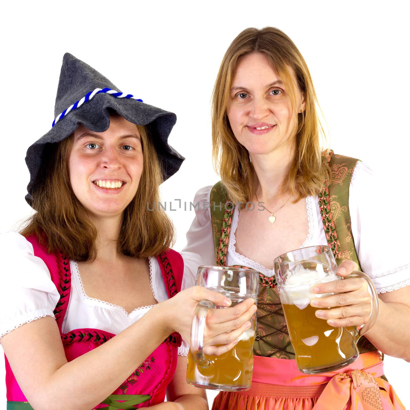 Women in dirndl clinking glasses by gwolters