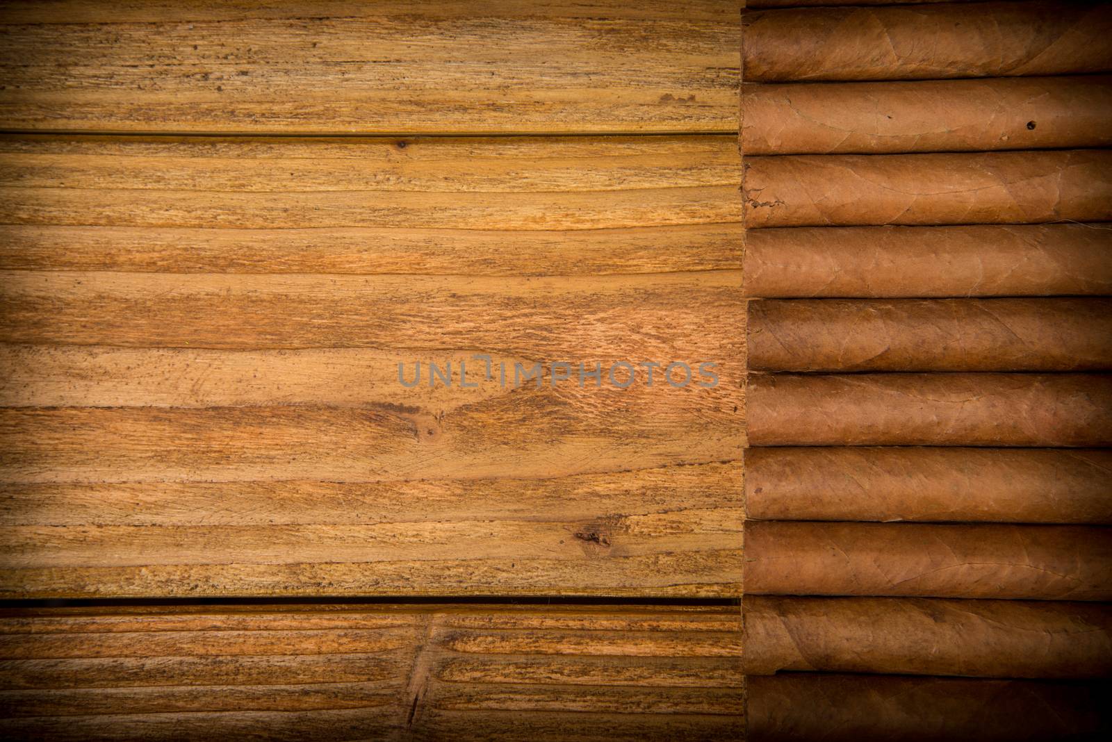 Cuban cigars on rustic wooden table in line on the edge of background