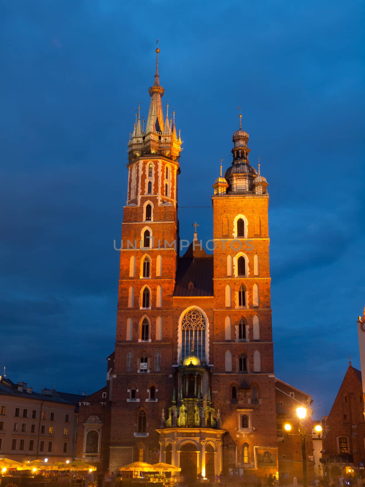 St. Mary's Church with two different towers by night (Krakow, Poland). Front view.