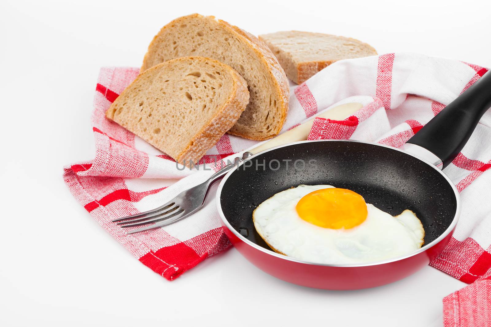 Fried egg in a frying pan, over white background