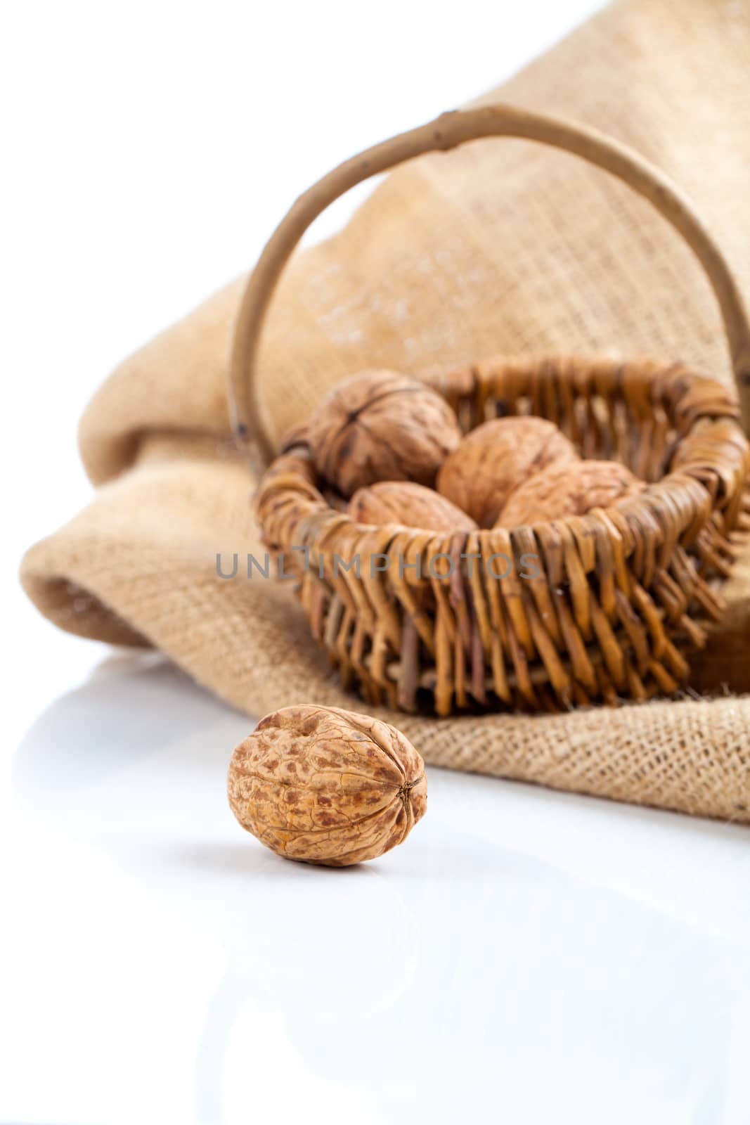 close up of walnut on white background (wicker basket full walnu by motorolka