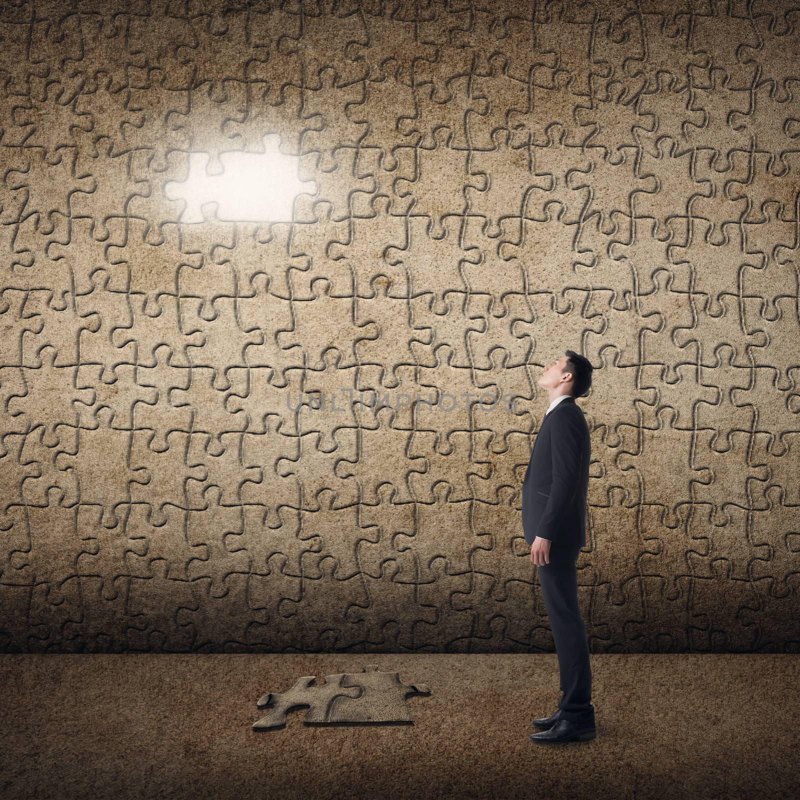 Asian man standing in front of a puzzle wall. Concept of mystery, problem, solution.