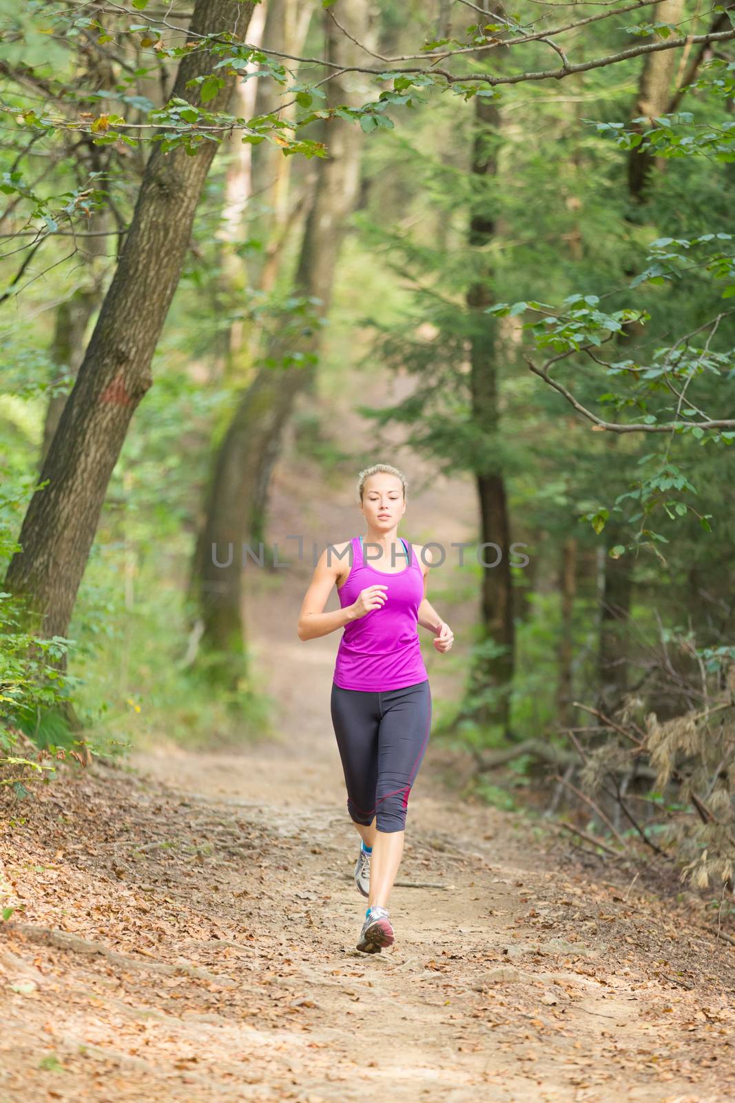 Pretty young girl runner in the forest.  Running woman. Female Runner Jogging during Outdoor Workout in a Nature. Beautiful fit Girl. Fitness model outdoors. Weight Loss. Healthy lifestyle. 