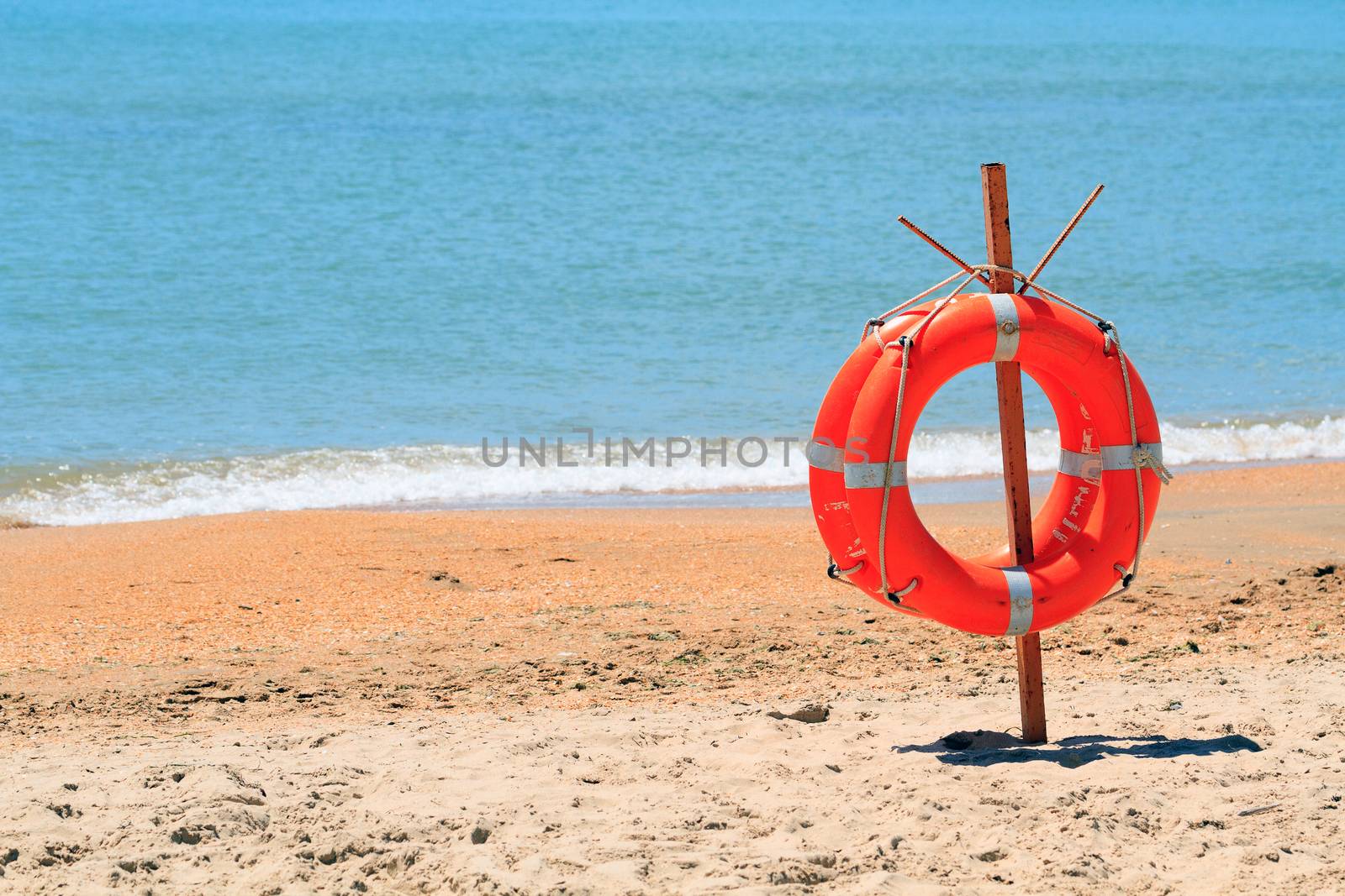 lifebuoy on a beach by Nobilior