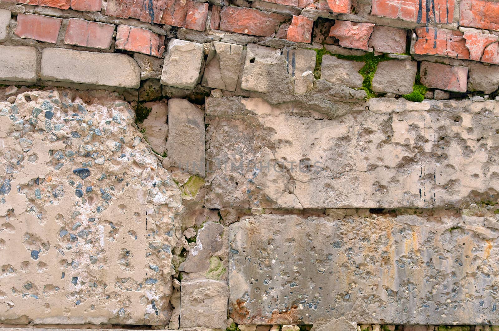 Old ruined concrete wall with red bricks