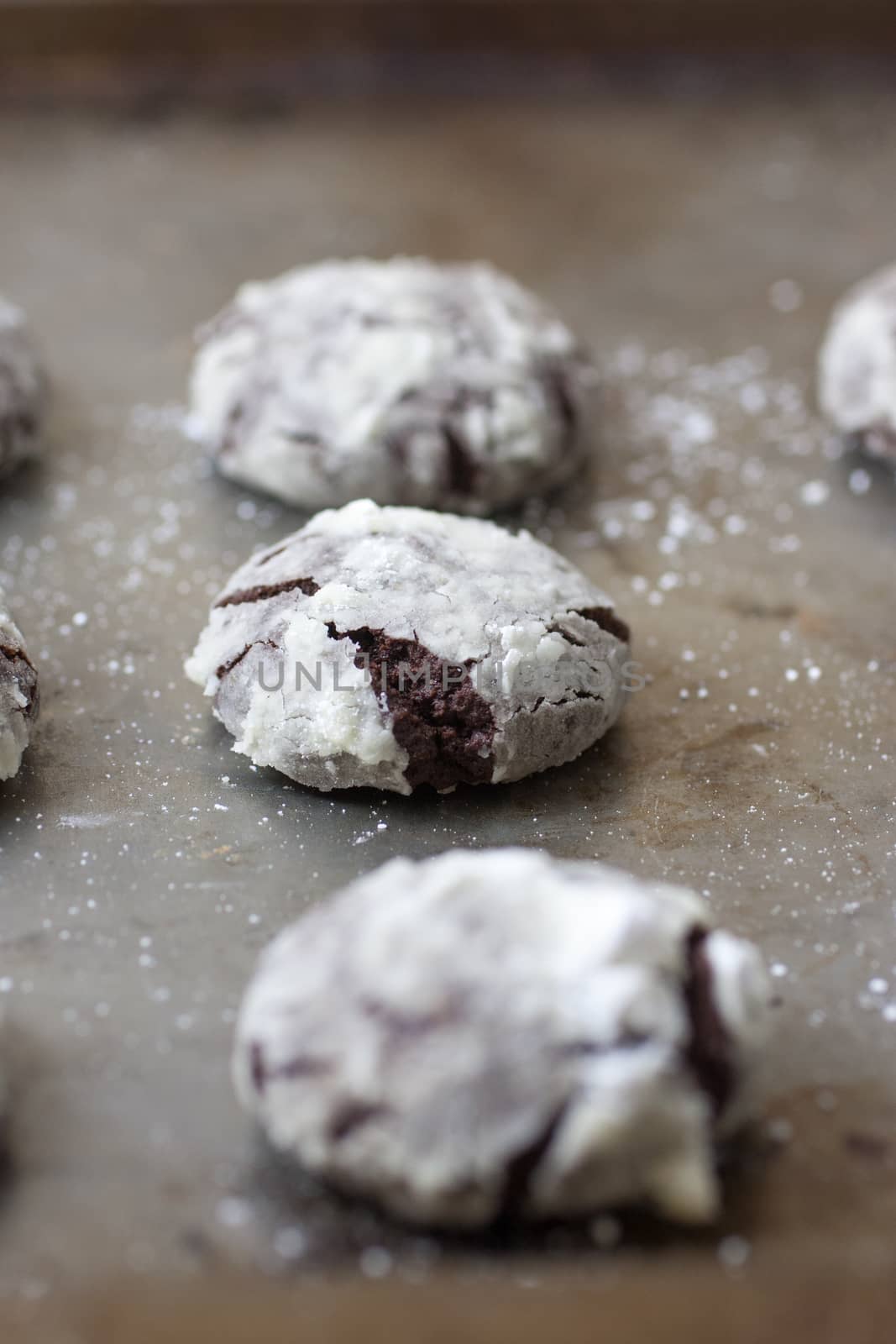 Chocolate crackle cookies with powdered sugar coating.