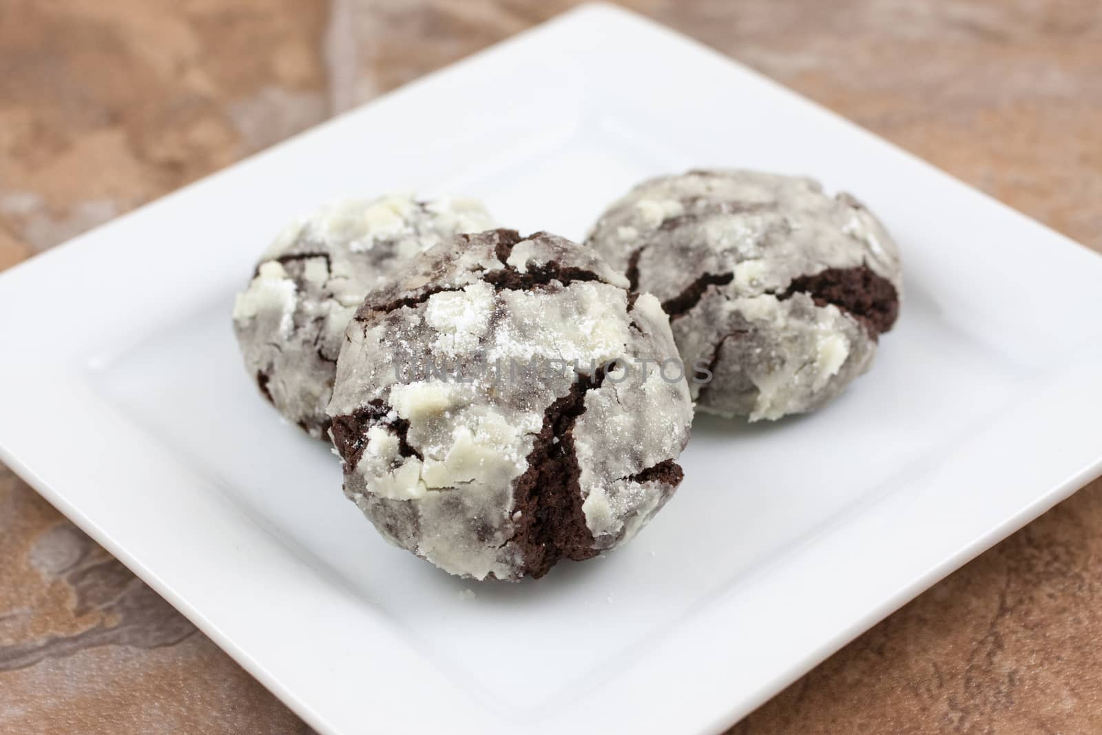 Chocolate crackle cookies with powdered sugar coating.