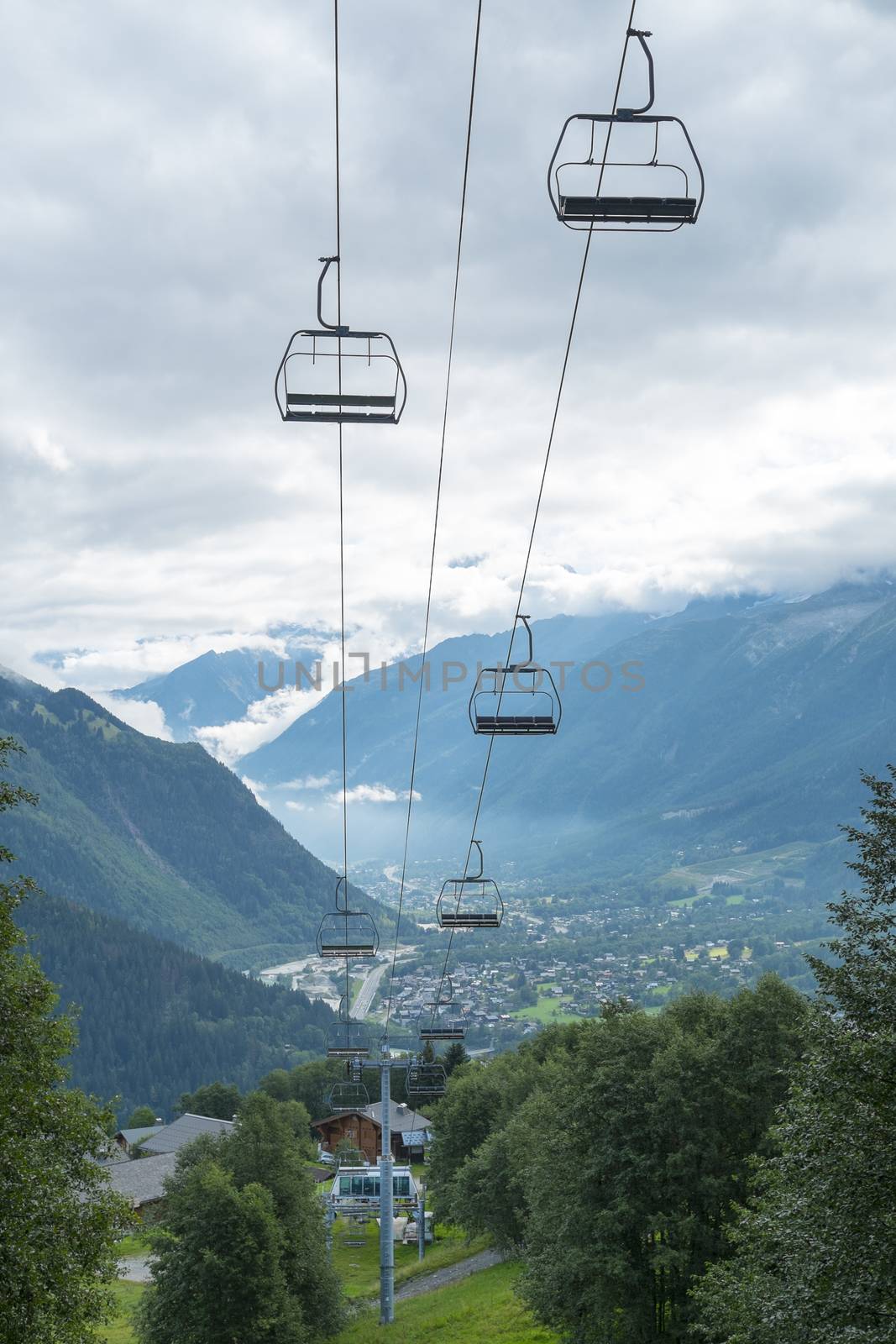 LES HOUCHES, FRANCE - AUGUST 23: Low angle shot of alpine air lift with Les Houches in the background. Les Houches is one of the Tour du Mont Blanc villages. August 24, 2014 in Les Houches.