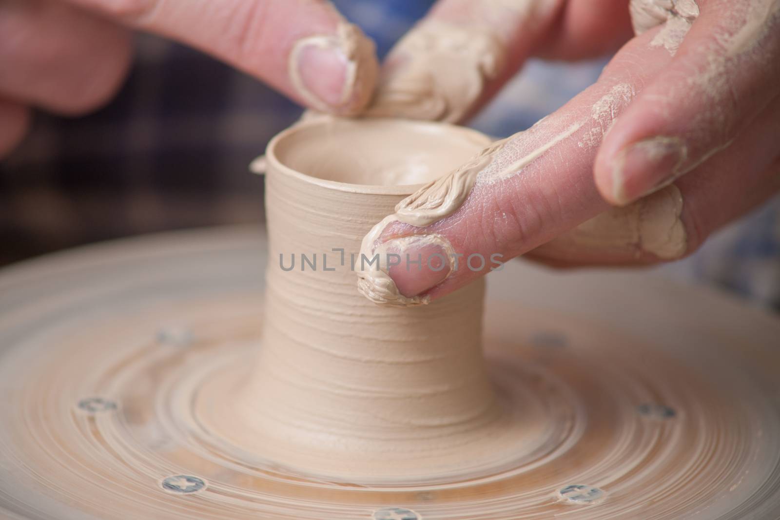 Hands of a potter, creating an earthen jar on the circle