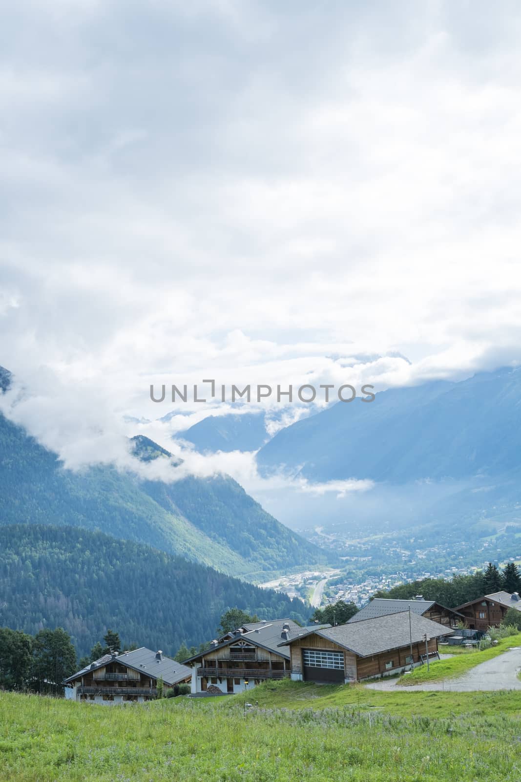 COL DE VOZA, FRANCE - AUGUST 24: Chalets with Les Houches village in the background. Les Houches is one of the Tour du Mont Blanc villages. August 24, 2014 in Col de Voza.