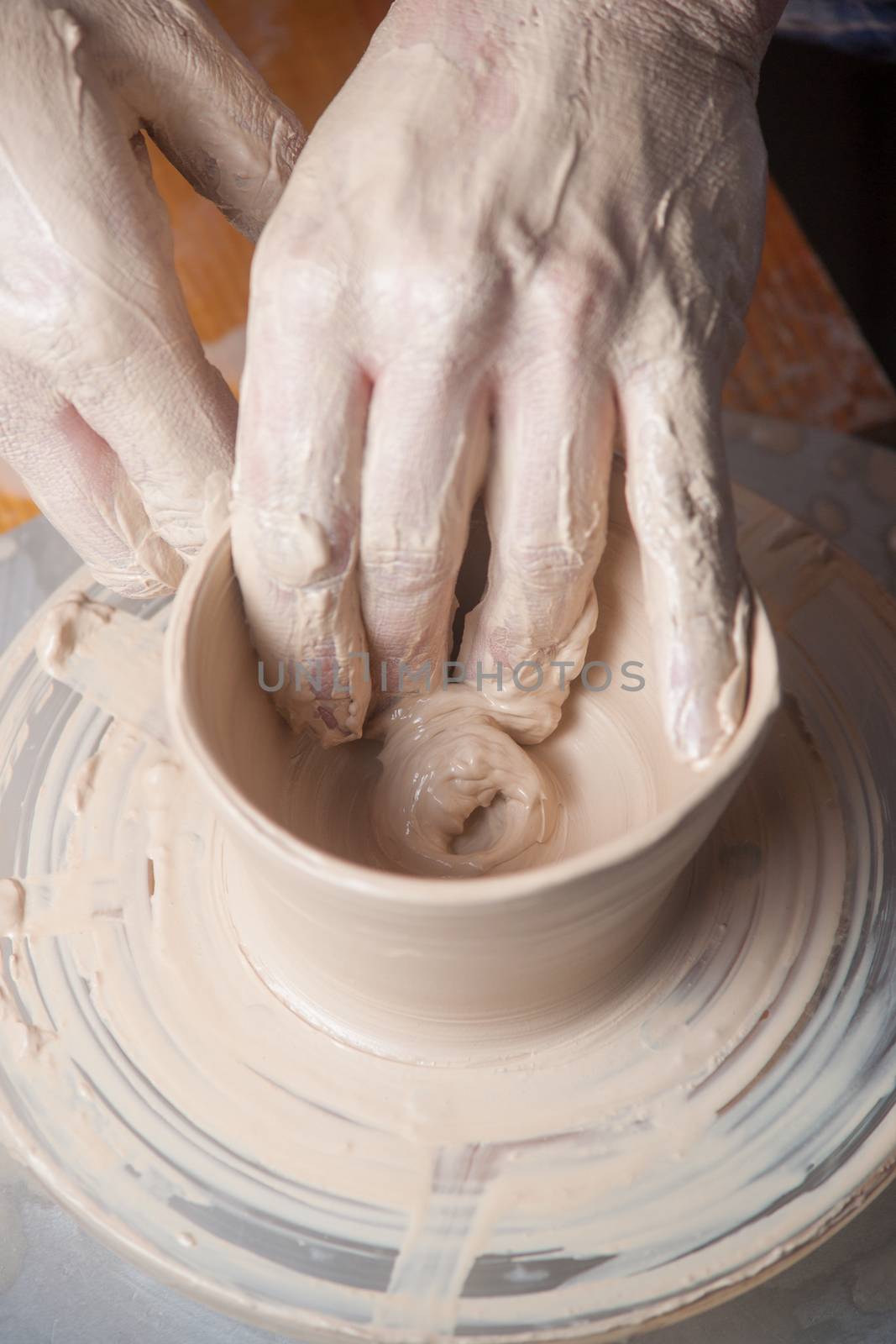 Hands of a potter, creating an earthen jar on the circle