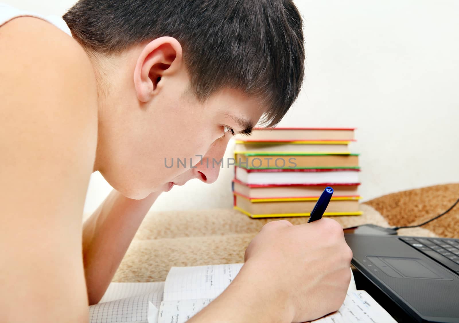 Side view of the Teenager doing Homework at the Home
