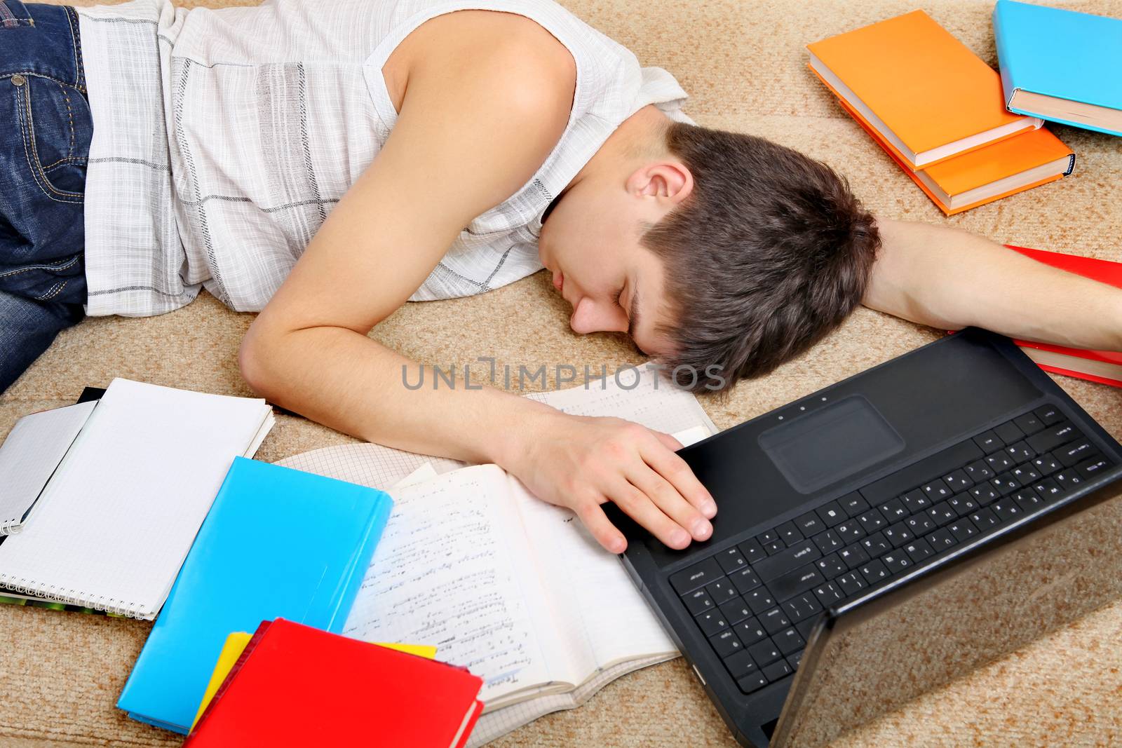 Tired Teenager sleeping on the Sofa with the Books