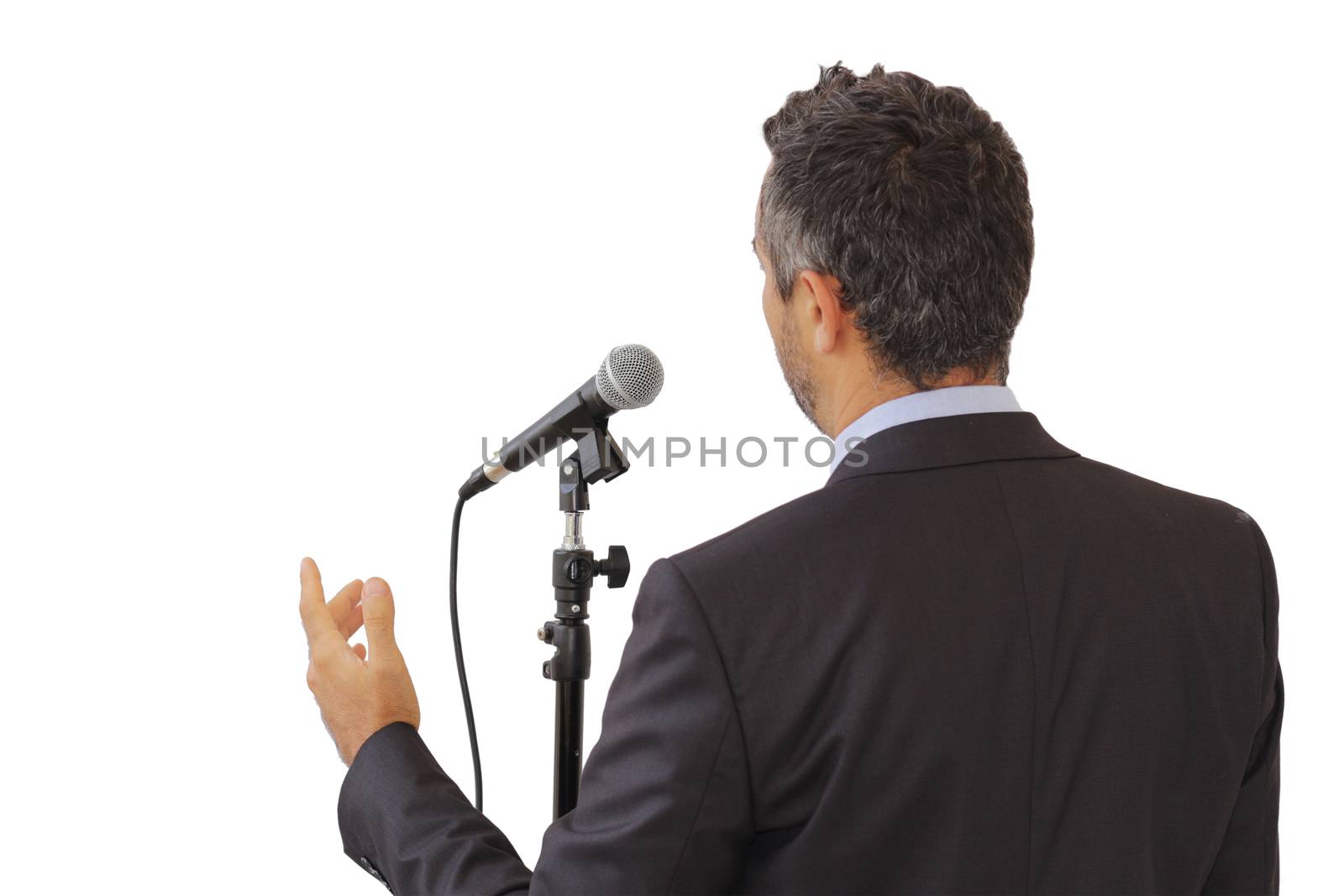 Rear view of a male public speaker speaking at the microphone, pointing, isolated with white background, symbol of leadership and international conferences