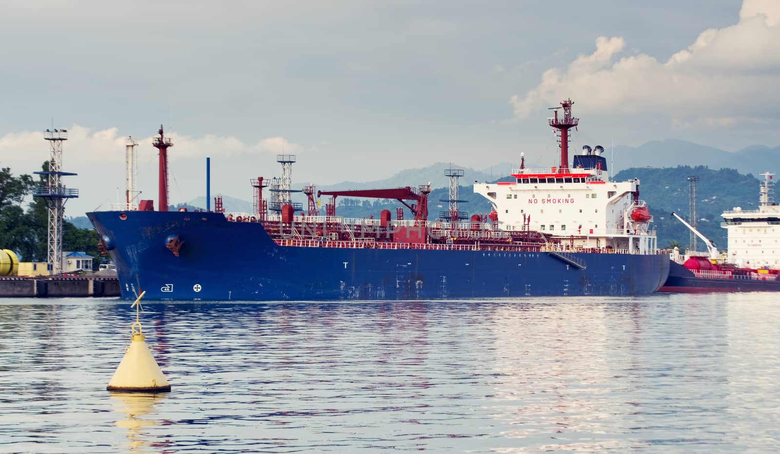 Tanker in port. Oil tanker in the proccess of unloading