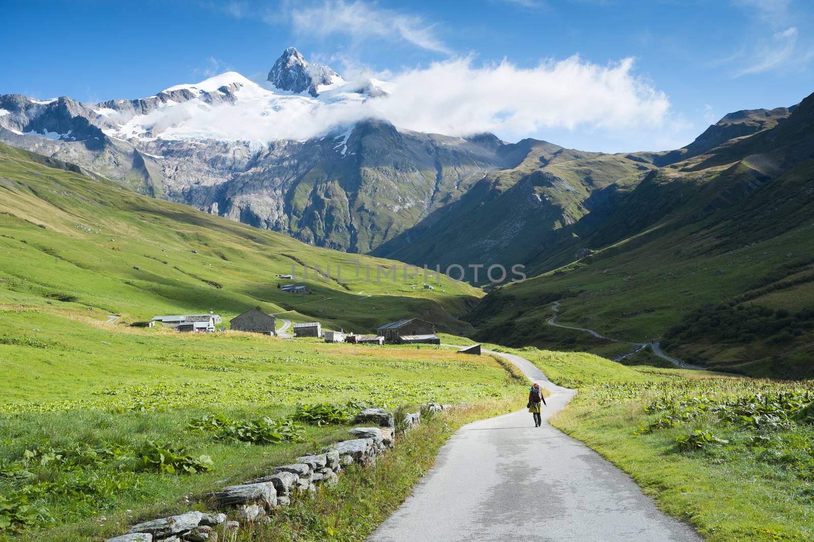 VILLE DES GLACIERS, FRANCE - AUGUST 27: Hiker walking towards Glacier Needles. The region is a stage at the Mont Blanc tour, which crosses three countries. August 27, 2014 in Ville des Glaciers.