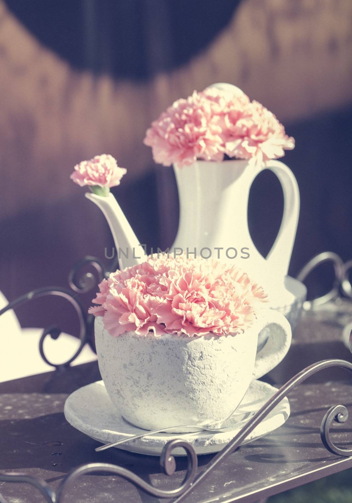 Picture of a composition with white teapot, cup and pink flowers