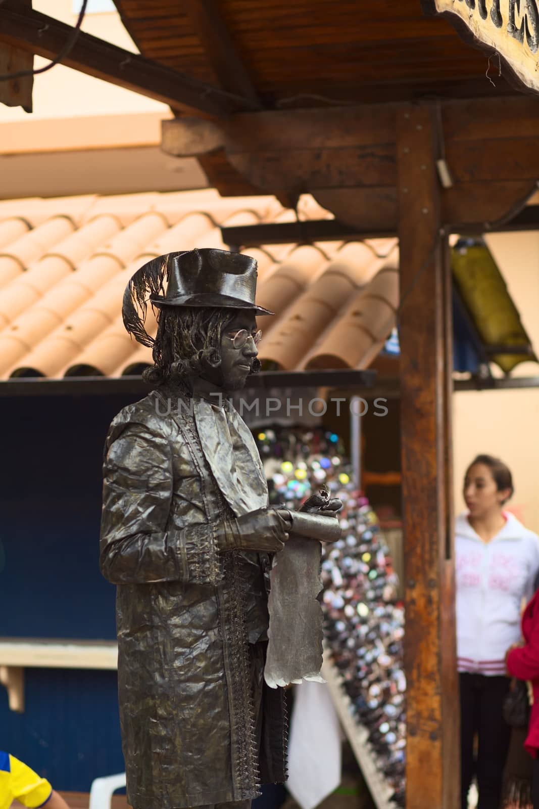 BANOS, ECUADOR - FEBRUARY 22, 2014: Unidentified person standing as a living statue posing as a poet at the Pasaje Artesanal (Artisan Passage) on February 22, 2014 in Banos, Ecuador. 